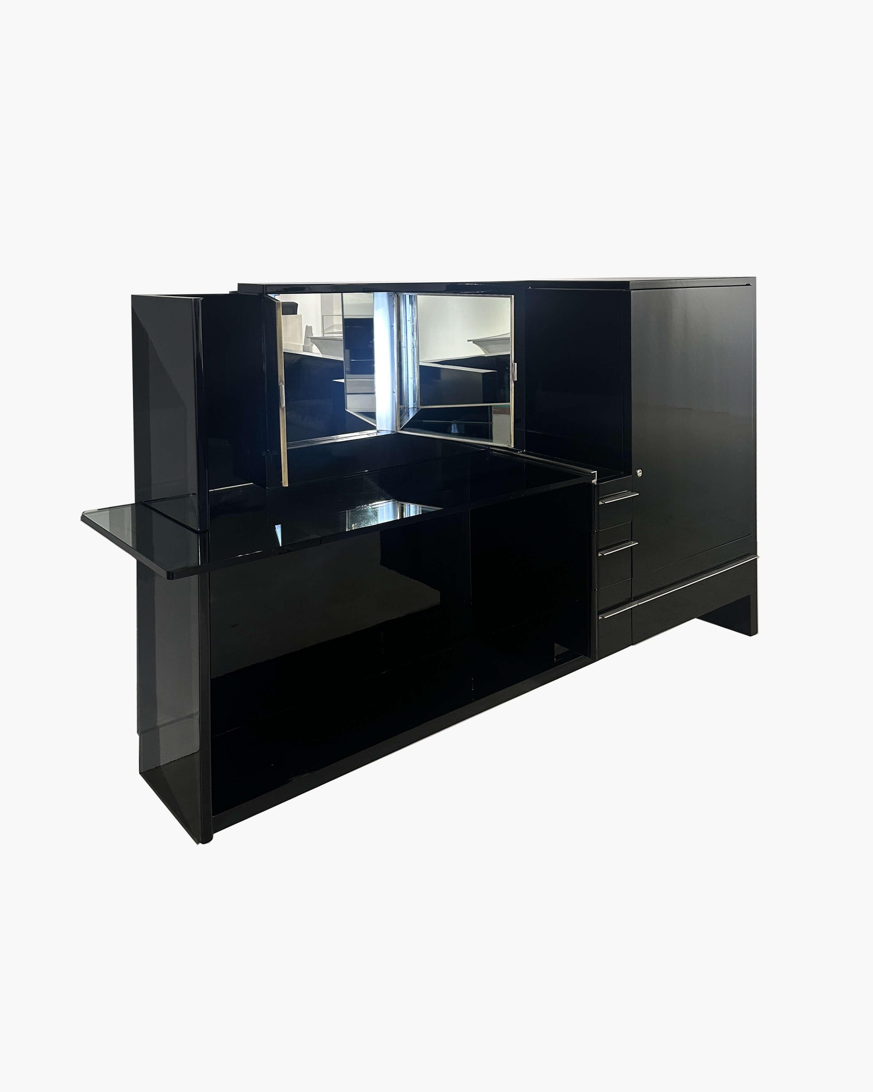 Questo elegante mobiletto di Louis Sognot presenta un raffinato equilibrio tra funzionalità e raffinatezza Art Déco. Il design, ora splendidamente rifinito in lacca nera, presenta una struttura accuratamente aggiornata con uno scomparto laterale