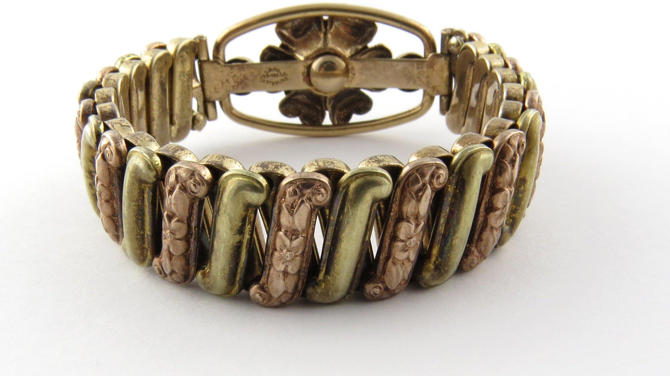 Vintage Louis Stern 12 Karat Gold Filled over Sterling Silver Expansion Bracelet- 
This lovely expansion bracelet by Louis Stern Co. features a beautiful floral center accented with ten red gemstones. Bracelet features alternating floral and plain