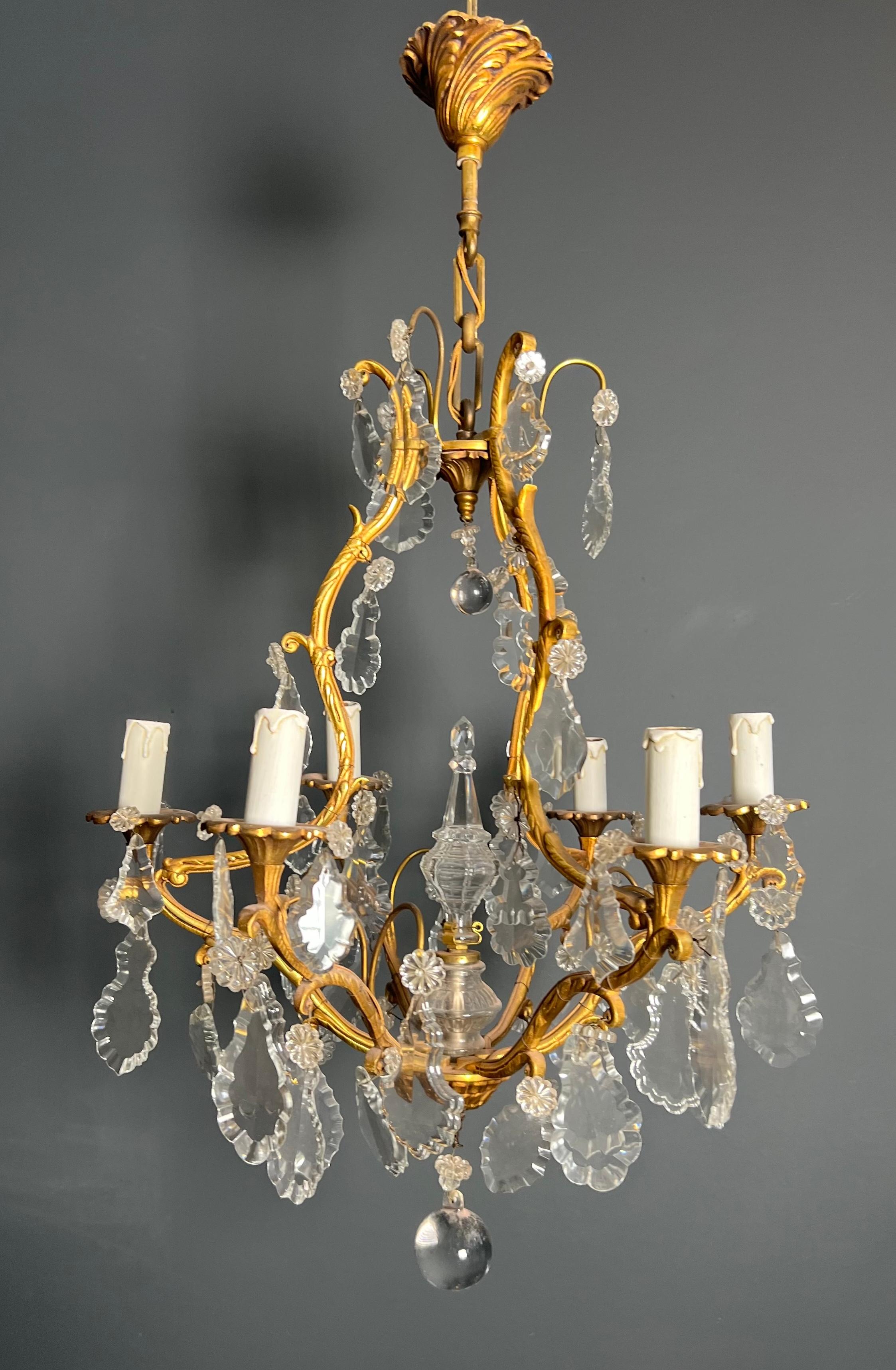Questo simpatico e decorativo lampadario a 6 bracci è realizzato in bronzo con pendenti in cristallo. Si tratta di un'opera francese nello stile di Luigi XV. Circa 1900