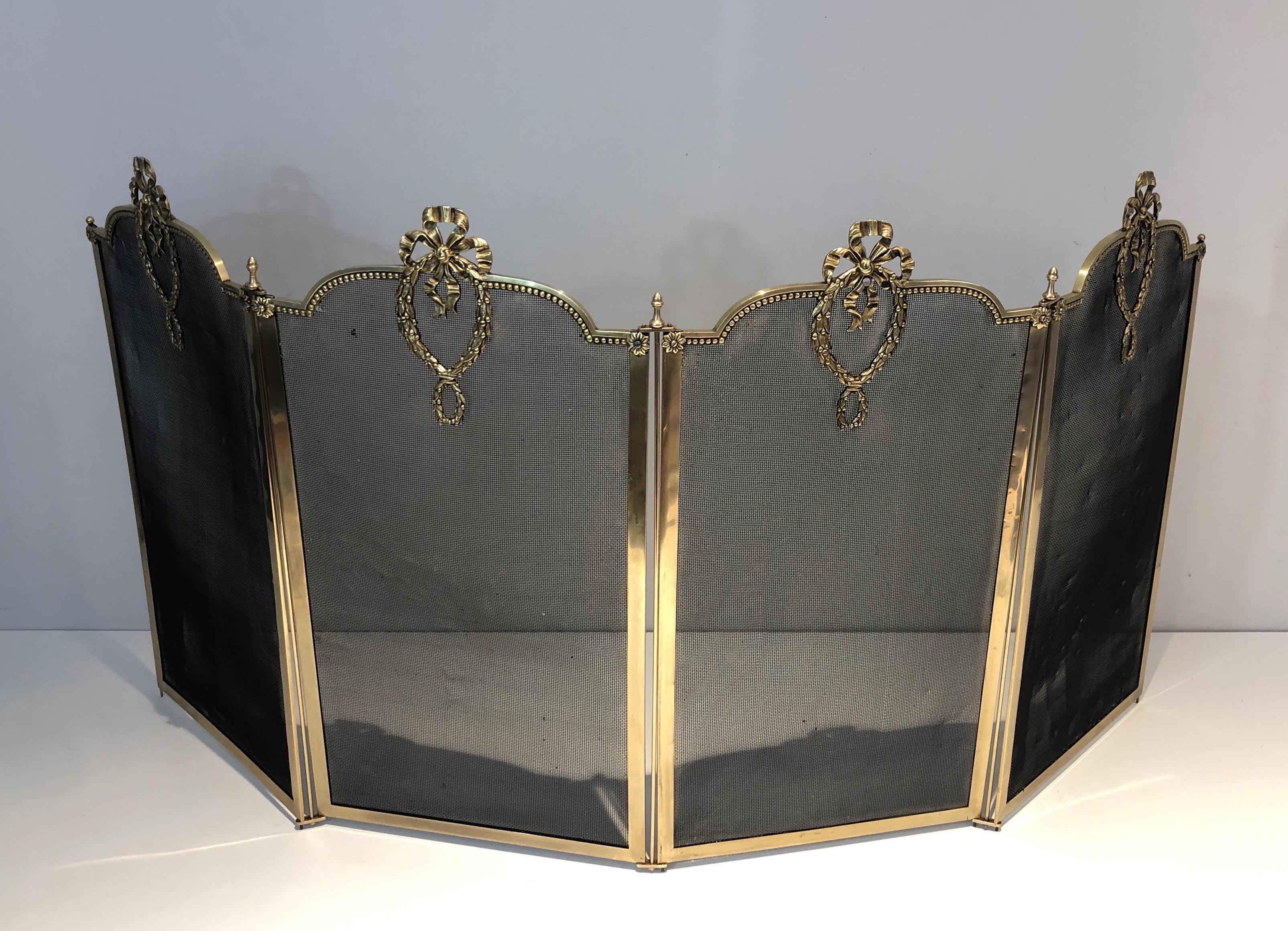 This Louis the 16th style 4 panels folding fireplace screen is made of brass and grilling. This firewall is decorated with bows, ribbons and garlands. This is a  French work, circa 1900.