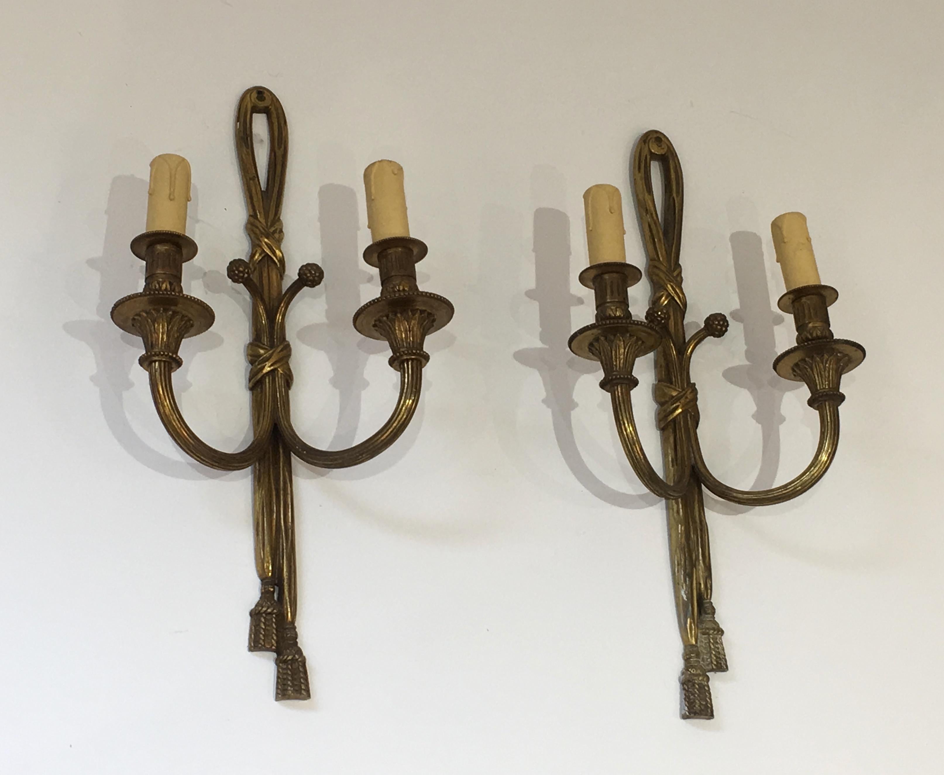 This nice and decorative pair of Louis XVI style wall sconces are made of chiseled bonze. This is a French work, circa 1940.