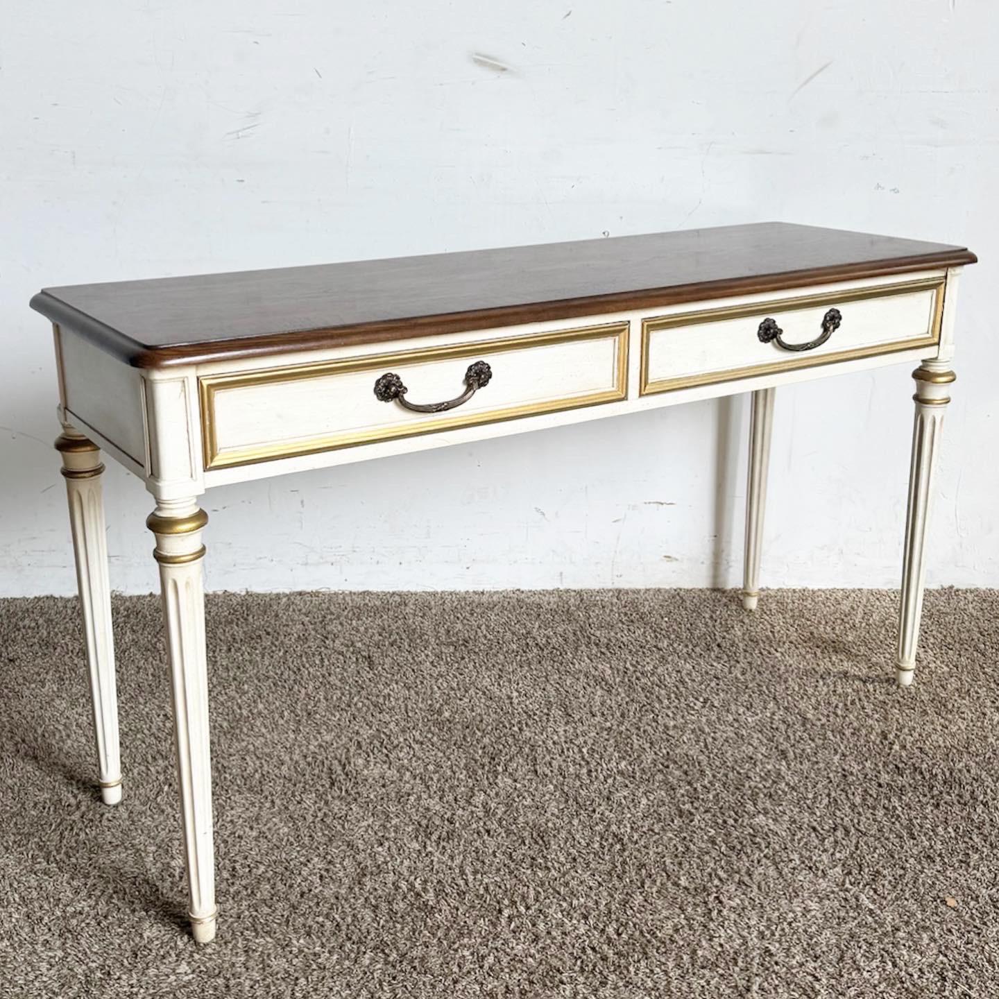 The Louis XVI Oak and Cream Console Table/Desk by Henredon marries timeless elegance with functionality. Its sturdy oak construction and cream finish reflect the classic Louis XVI style, perfect for adding a touch of regal charm to any