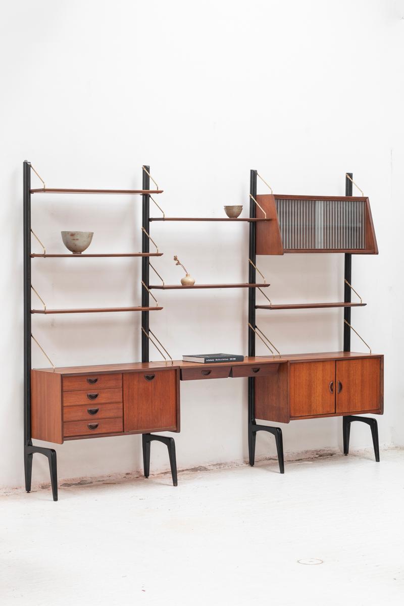 3-bay wall unit by Louis van Teeffelen for Wébé, Dutch design from the 1950s. Four organic uprights in original black lacquered limba wood, which don’t have to be wall mounted. The system consists of six teak shelves, 2 storage cabinets, a desk with