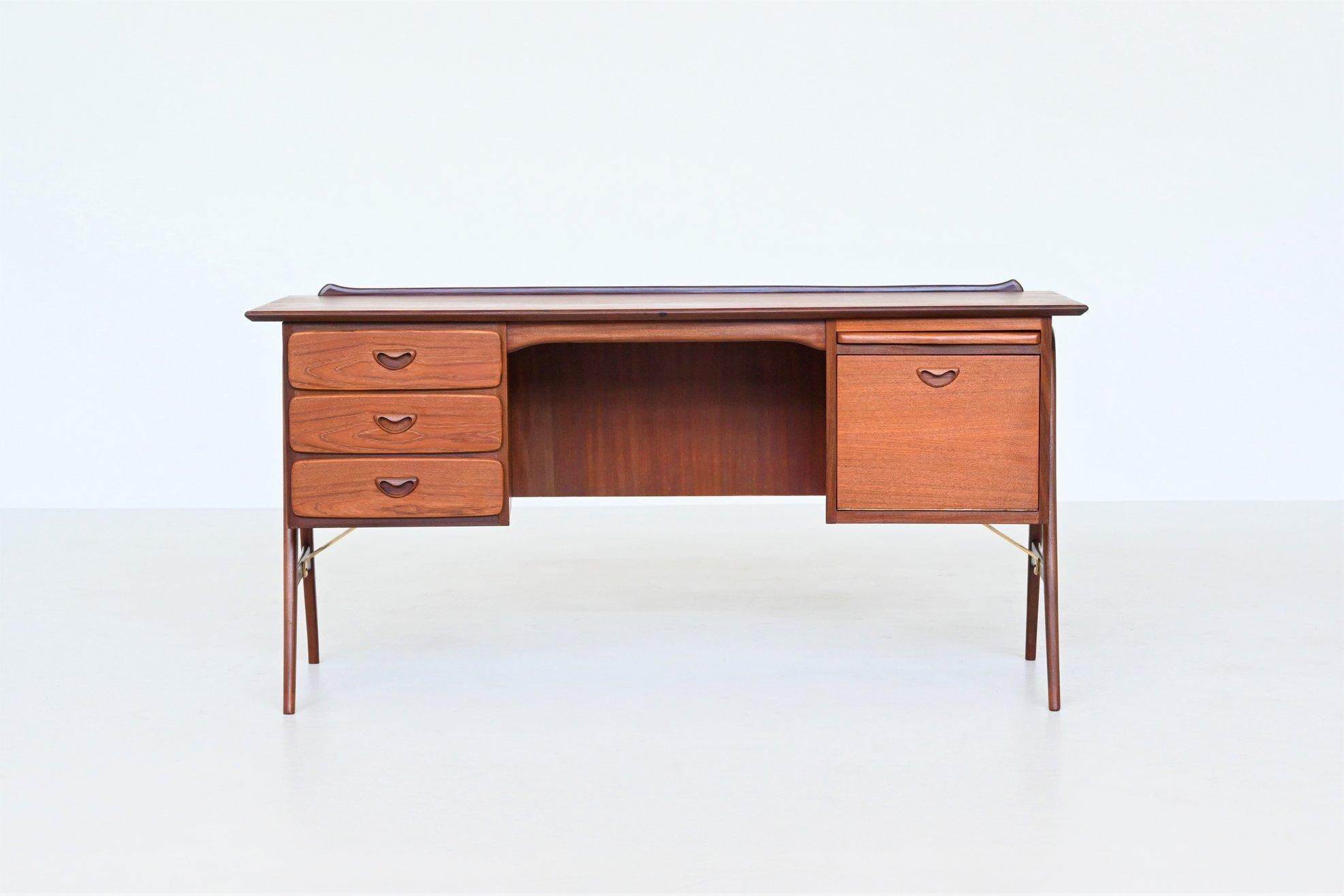 Beautiful boomerang shaped writing desk designed by Louis van Teeffelen and manufactured by Webe Meubelen, The Netherlands 1960. The desk is made of veneered teak wood and is supported by a solid teak wooden frame with brass details. This high