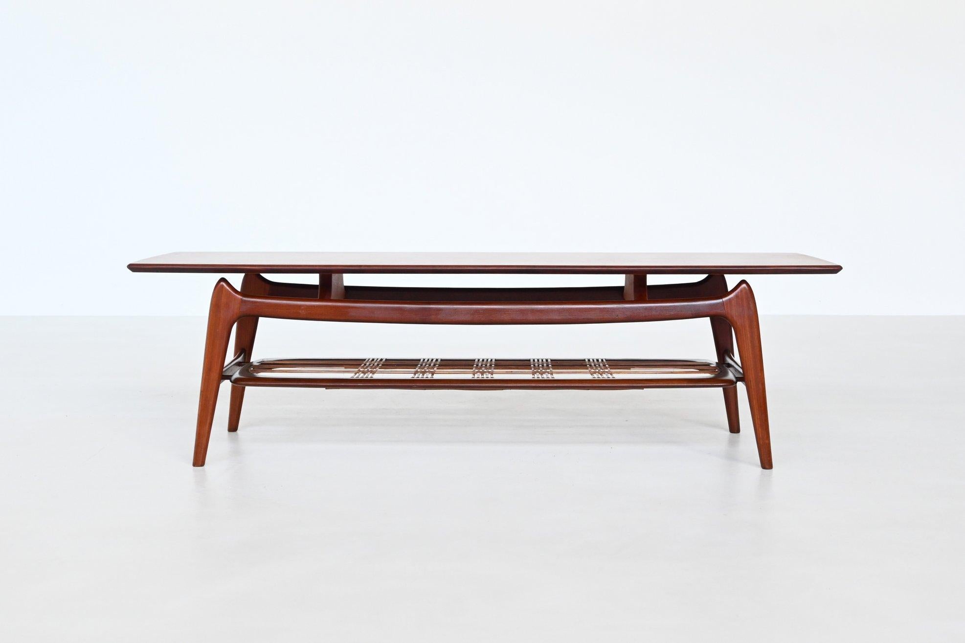 Beautiful shaped coffee table designed by Louis van Teeffelen and manufactured by Webe Meubelen, The Netherlands 1960. The table is made of veneered teak supported by an organic sculpted solid teak frame and it has an original woven rattan magazine