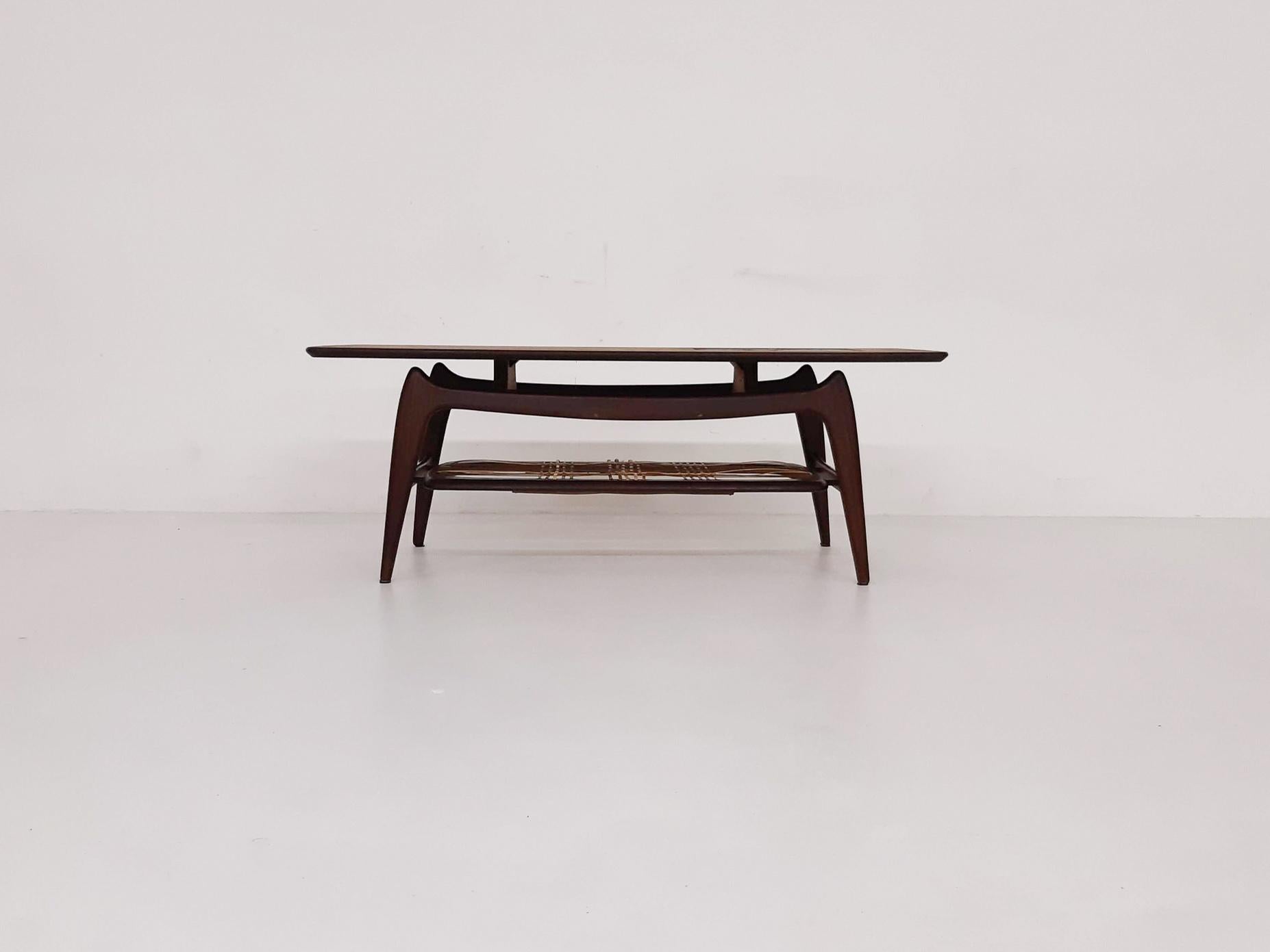 Wooden coffee table with Ravelli tiles on the top
A rattan magazine rack under the top. Some of the rattan strings have been replaced with new weaving.

Louis Van Teeffelen was the most important designer at Wébé. His work was often influenced by