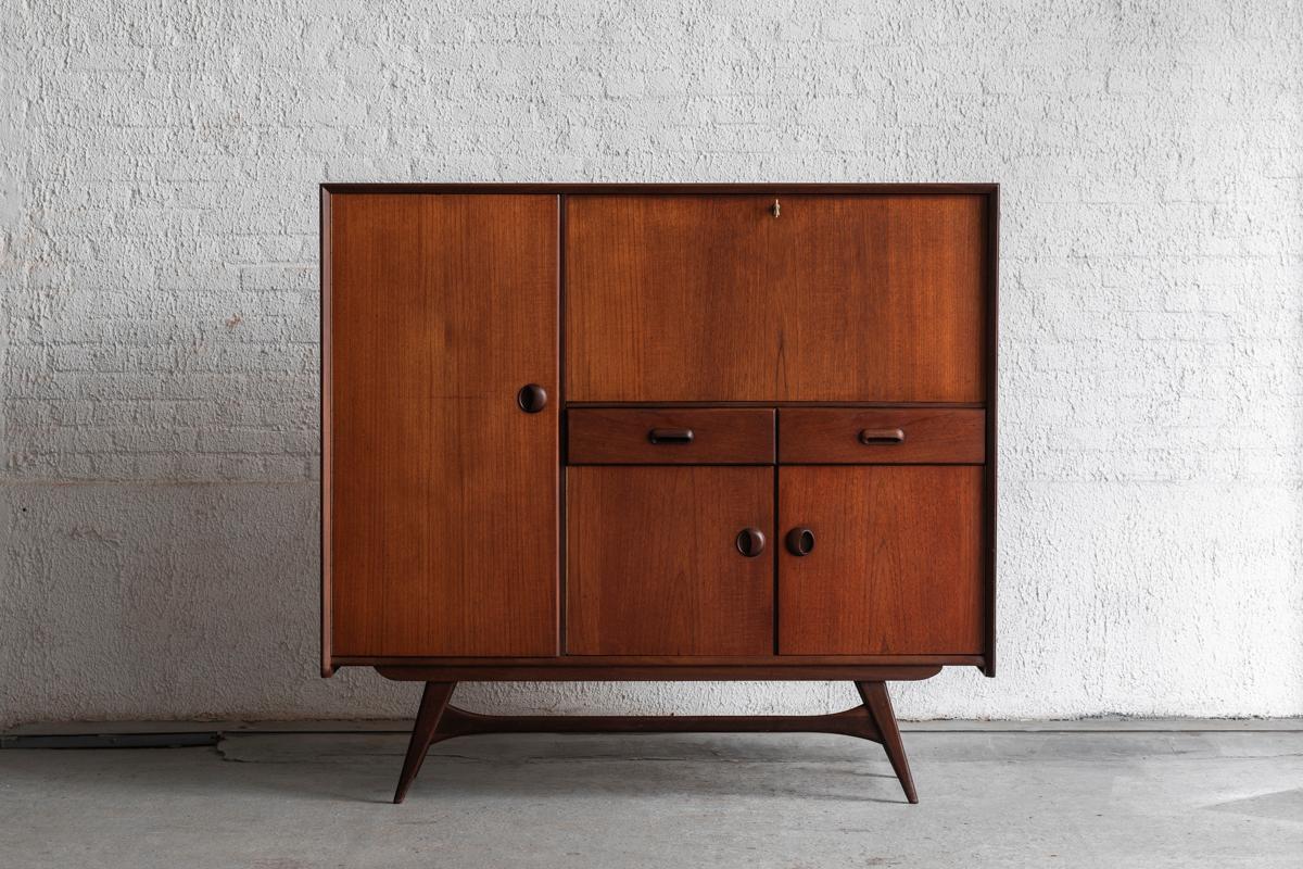 Cabinet designed by Louis van Teeffelen and produced for Wébé in The Netherlands in the 1960’s. It has solid teak legs and teak veneered cabinets and drawers. The bar compartiment can be locked with the present, original key. In very good condition