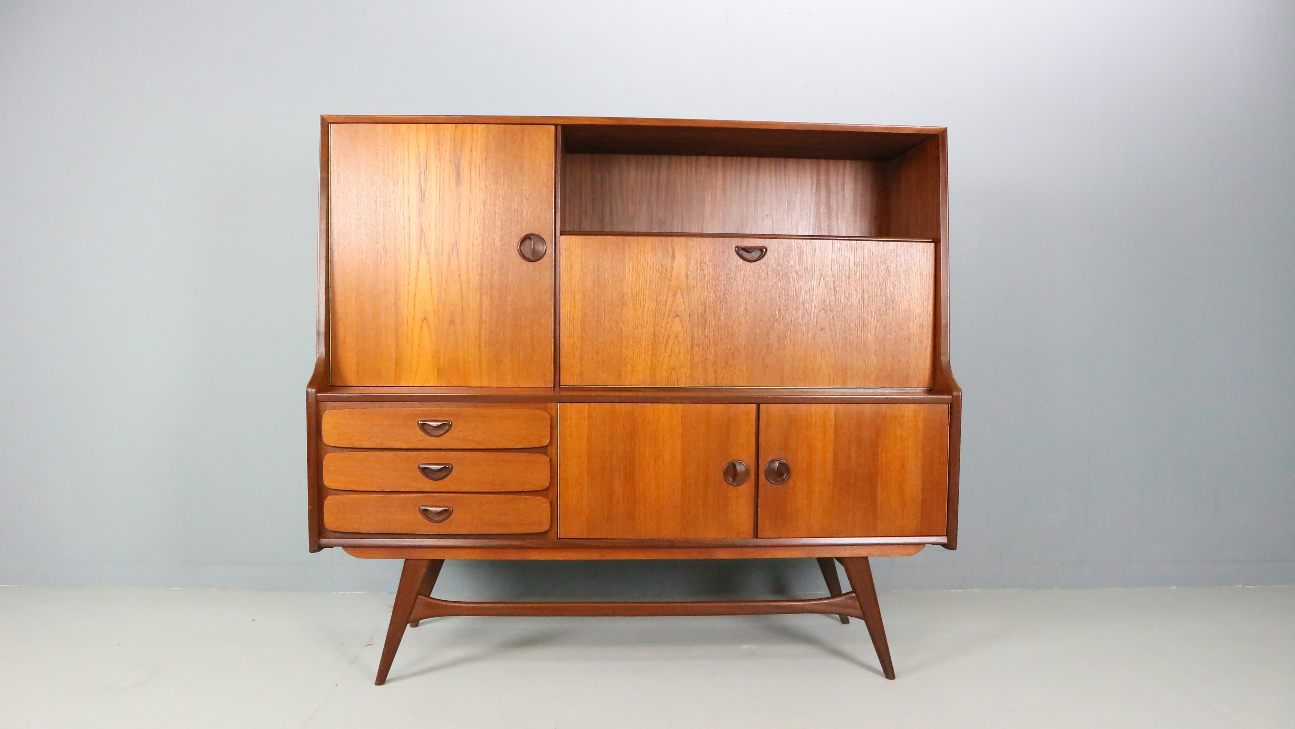 Splendida credenza vintage dal design olandese. Progettata da Louis Van Teeffelen per la fabbrica di mobili WéBé negli anni '60, Paesi Bassi.
Il mobile è realizzato in legno di teak e contiene tre cassetti, un'anta per il mobile dei liquori e un