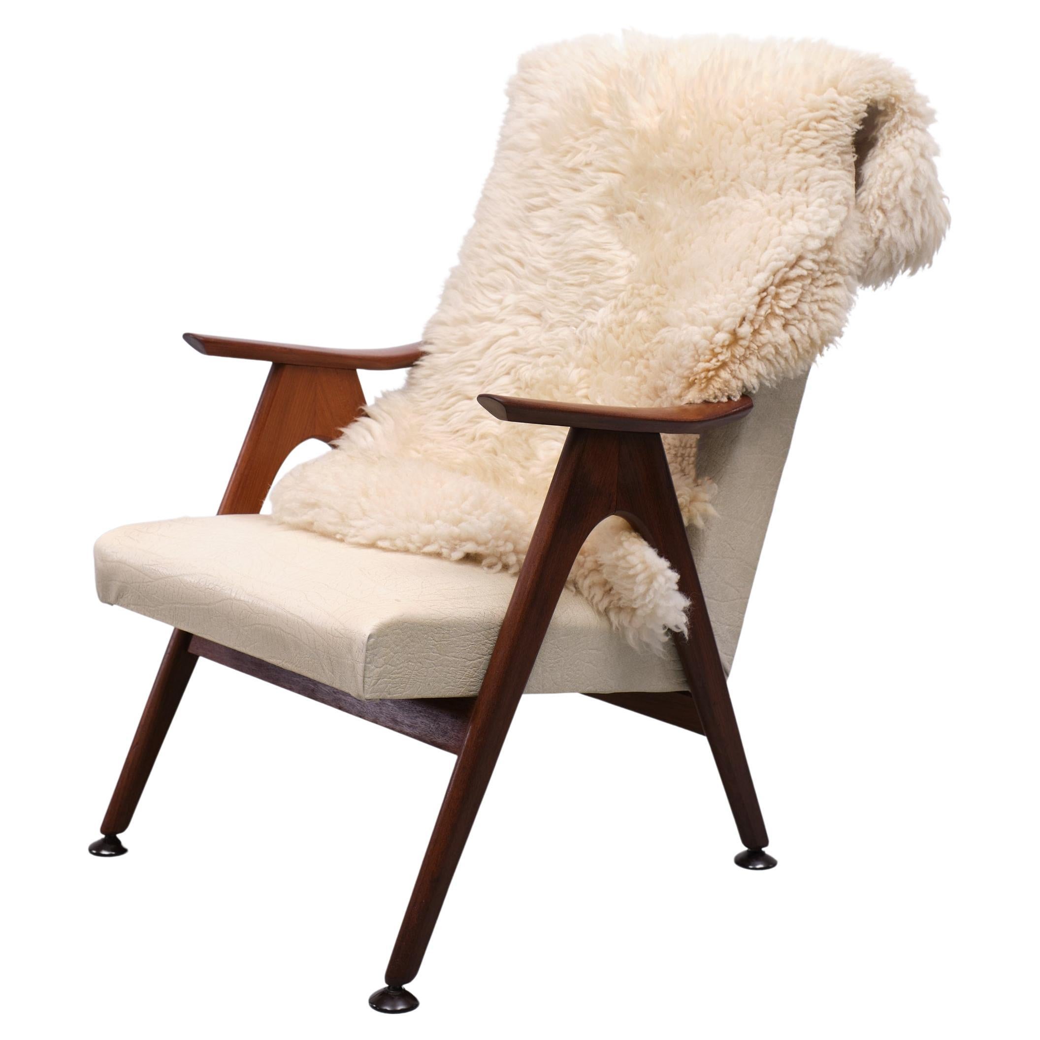 Very nice Teak lounge chair comes with a off White faux Leather upholstery. 
Design by well known Dutch designer Louis van Teeffelen. Recognizable for its organic 
furniture. Good condition.
