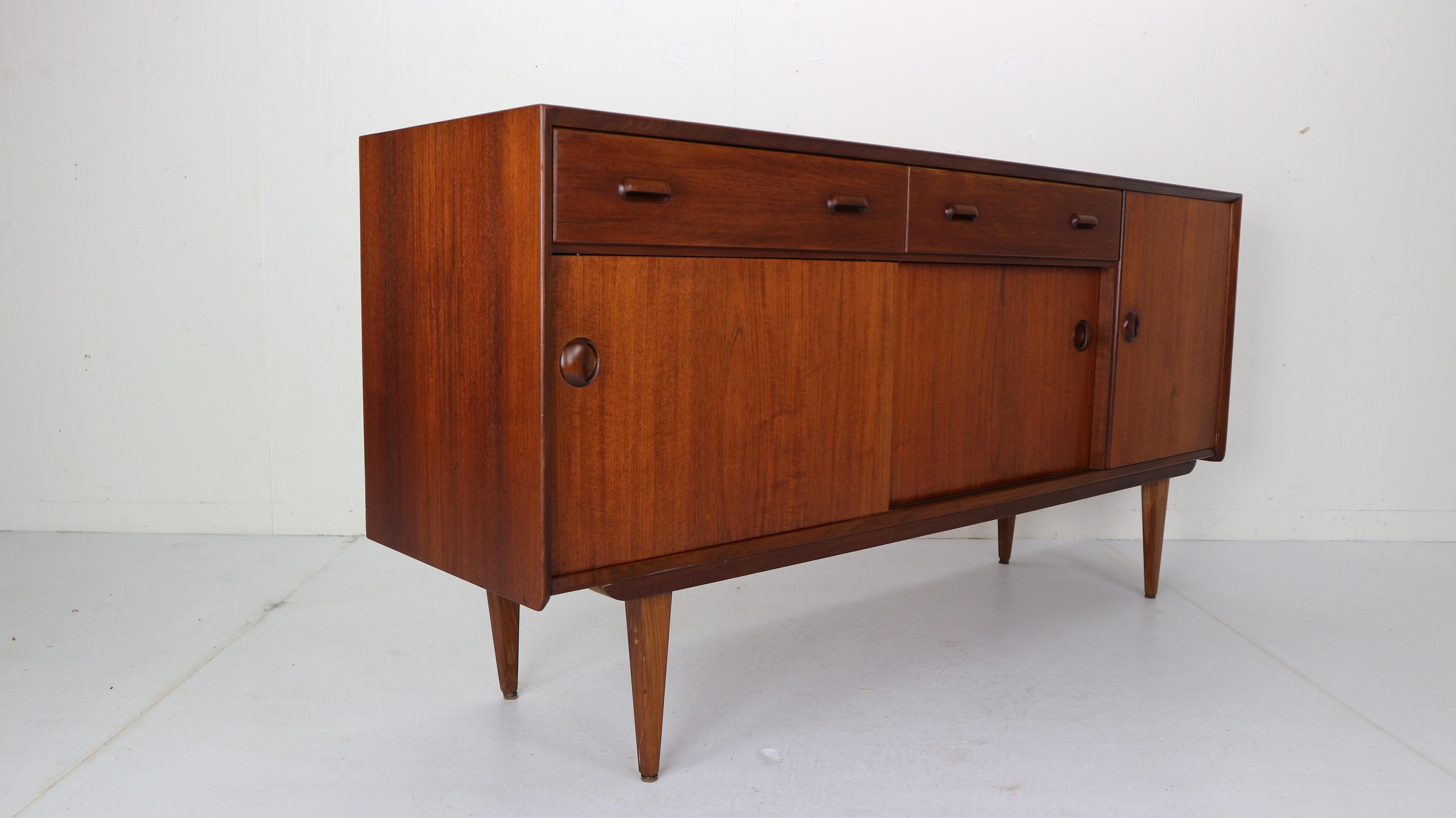 Wonderful vintage Dutch design sideboard/ credenza. Designed by Louis van Teeffelen for furniture factory Wébé in the 1960s, Netherlands.
The sideboard is made from teak wood and holds two drawers, two slide cabinets and one door cabinet, all on