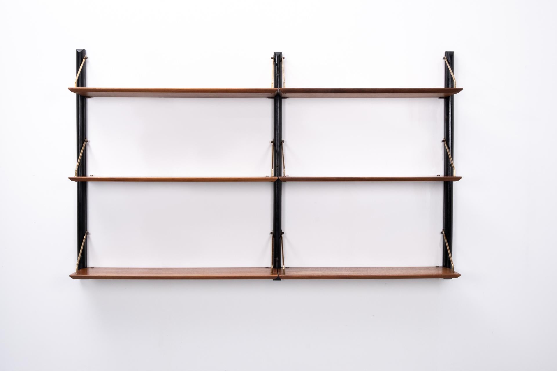 Beautiful wall unit. Three black ebonized uprights, holding 6 teak shelves. Solid brass brackets.
Superb quality and condition. With just the right amount off patina. Nice warm color on the teak shelves.
Comes with the original brass screws.
 