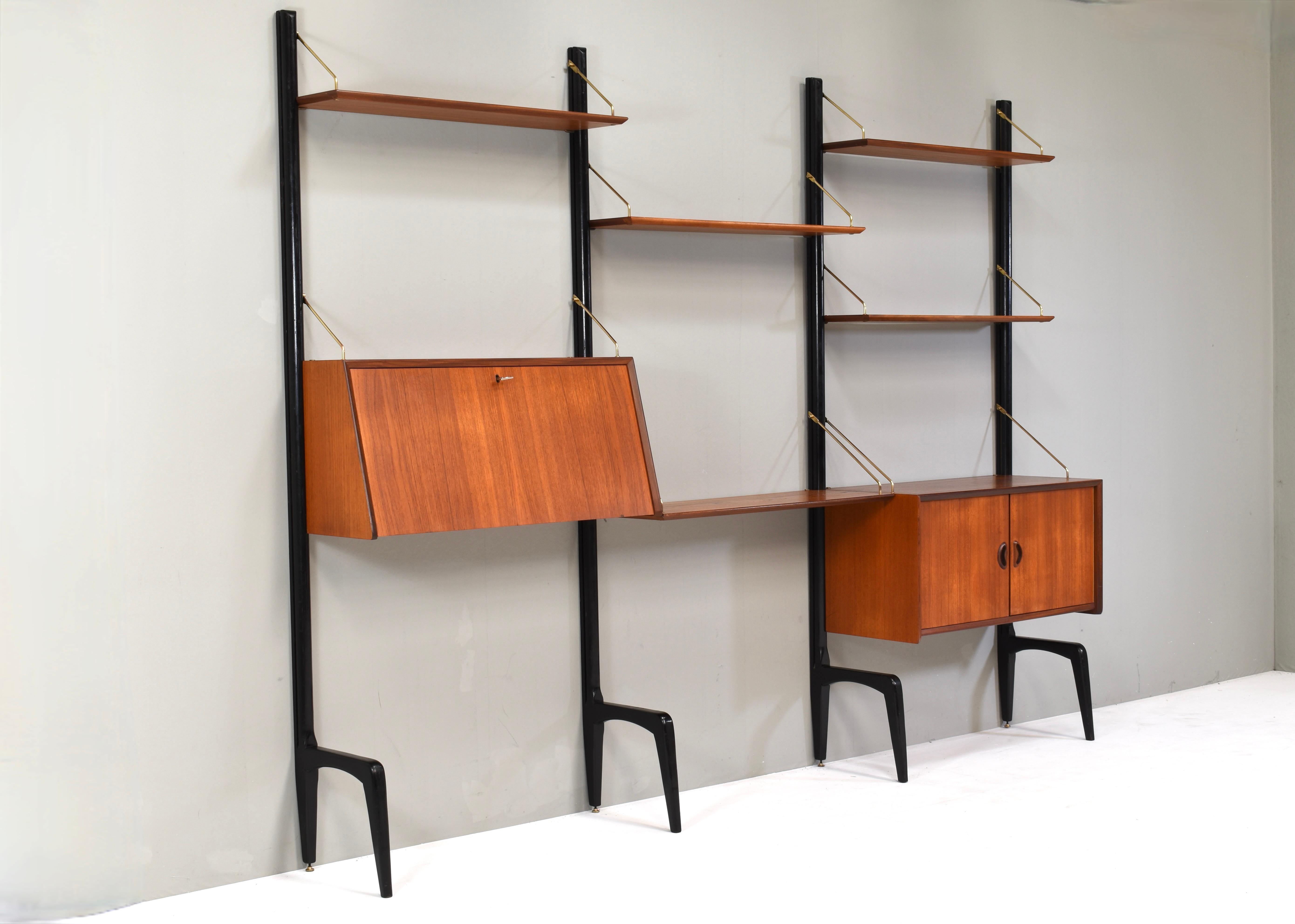 Elegant wall-unit by Louis Van Teeffelen for WéBé (Walraven & Bevers), Netherlands – circa 1950.

The wall unit is made of black lacquered wood pilars, teak veneer shelves and cabinets and brass hinges.
The pilars have adjustable brass feet for
