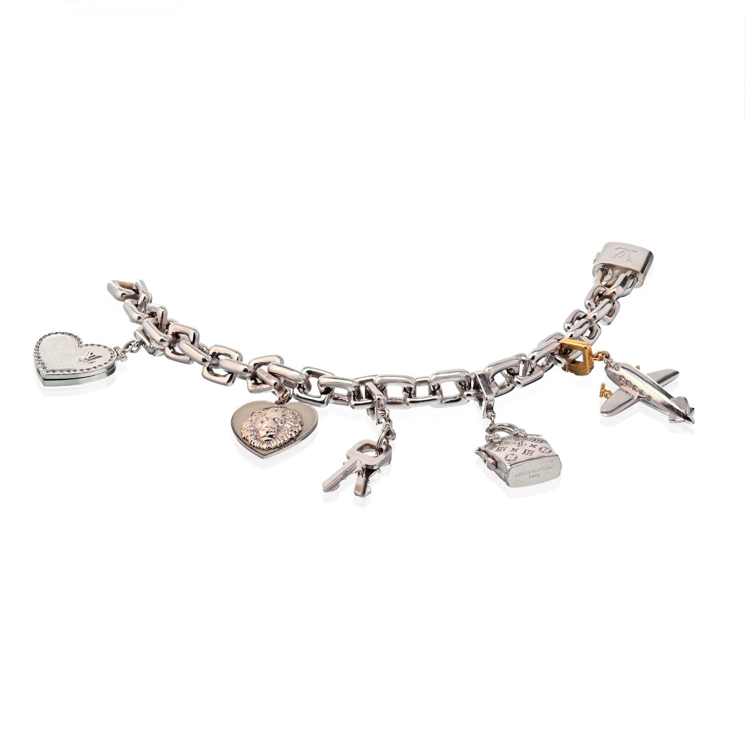 The Lockit bracelet suspends six removable charms featuring a plane, heart, podlock, keys, lion and a purse, enhanced by a round-cut sapphire, set in 18k white and yellow gold; all marked LV for Louis Vuitton with French hallmarks. 
Gross weight of