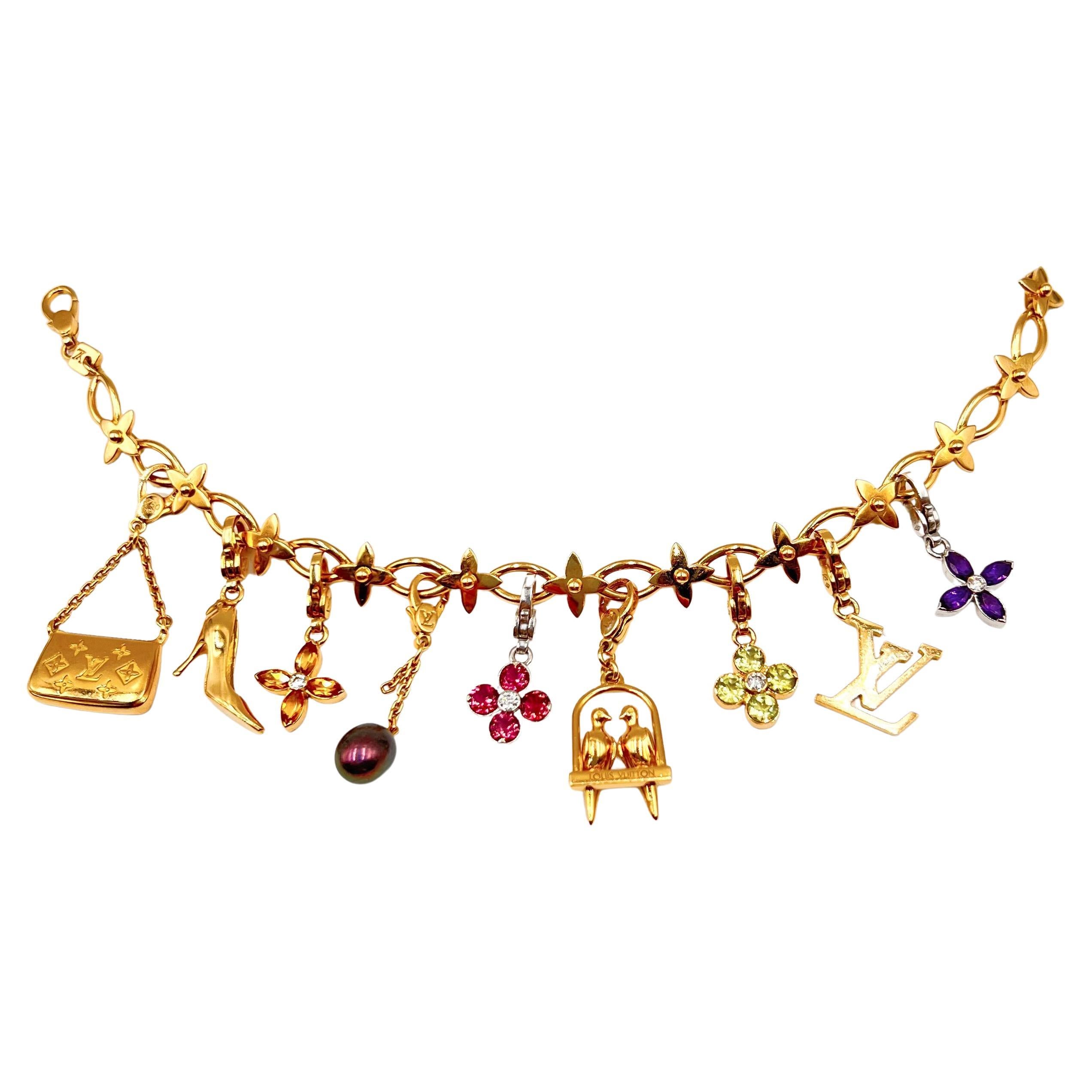 Louis Vuitton bracelet in 18kt yellow gold with nine Louis Vuitton detachable charms.  The miniature Louis Vuitton charms include a Louis Vuitton purse; LV high heel shoe; LV citrine diamond flower; LV black cultured pearl on chain; LV 18k white
