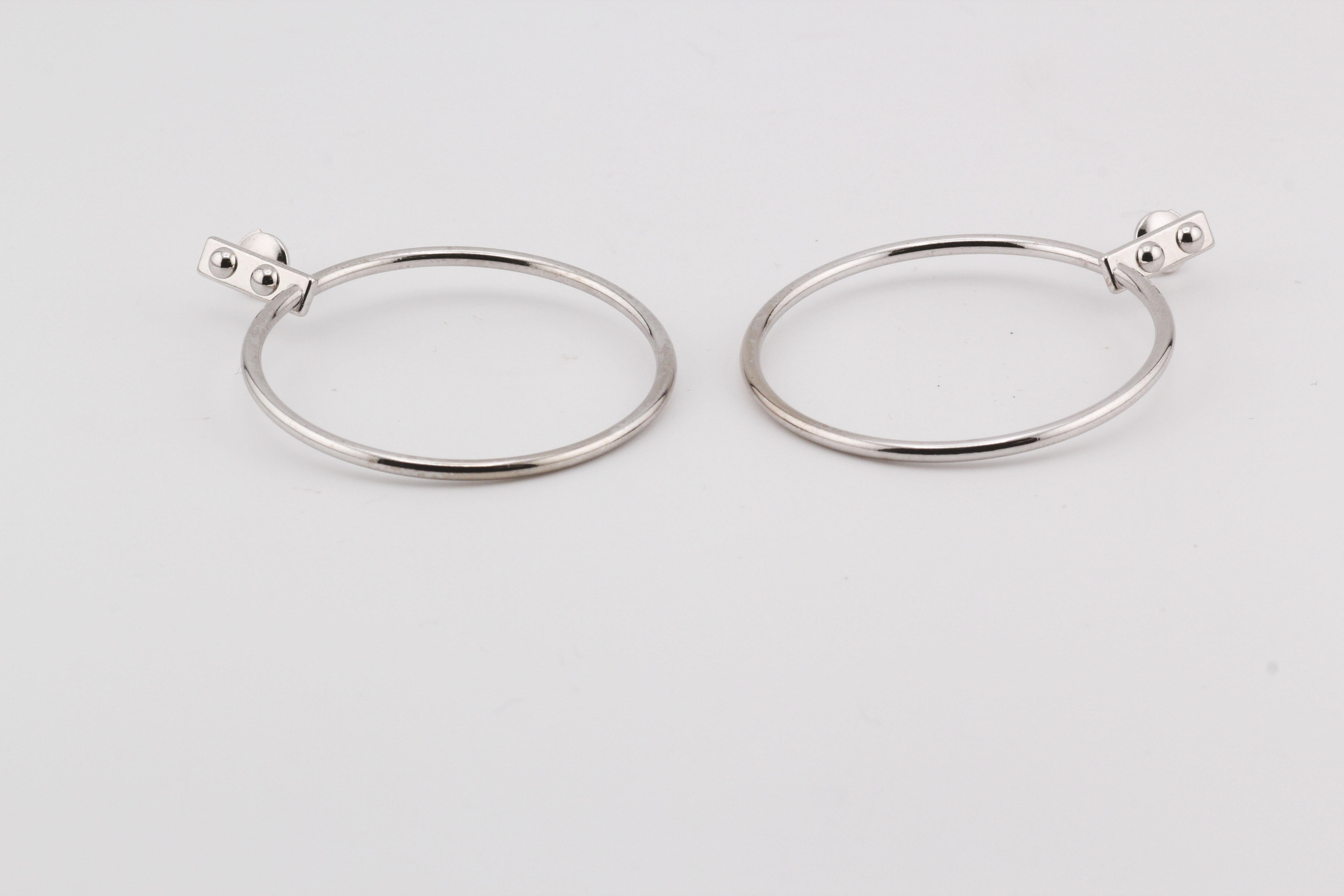 The Louis Vuitton 18K White Gold Drop Hoop Earrings are a sophisticated fusion of modern design and timeless elegance. Crafted from radiant 18k white gold, these earrings feature an innovative drop hoop design that reimagines the classic hoop