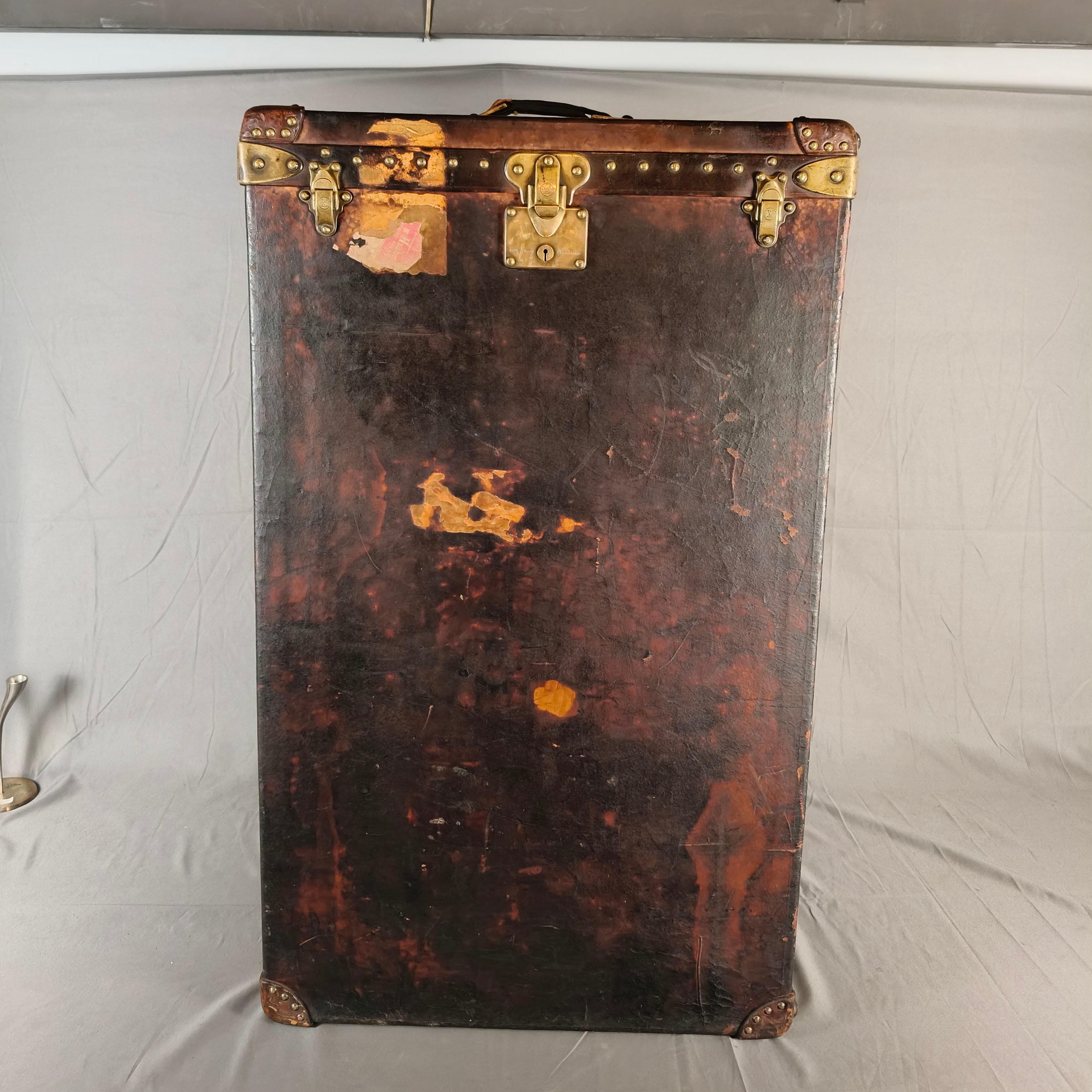 This 1930's Travel Trunk is in brown leather with brass hardware, it comes with the original Louis Vuitton lock with the number 108573 on the keyhole. It opens vertically to reveal one side with six original hangers, and two wooden straps to hold