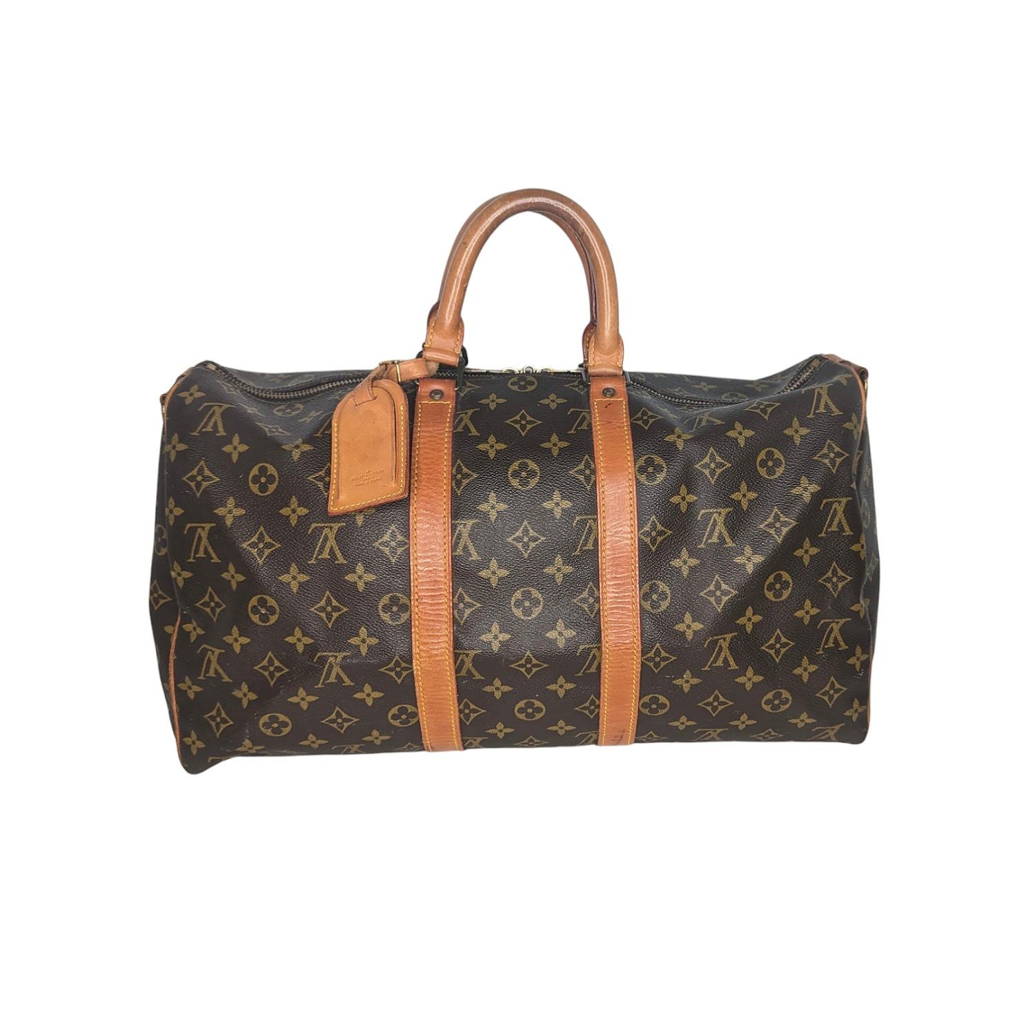 This stylish duffel is crafted of monogram coated canvas with vachetta leather wrap around detailing and rolled top handles with brass hardware. The top zippers open to a cocoa brown fabric interior. Est. Retail $1,420

Designer: Louis