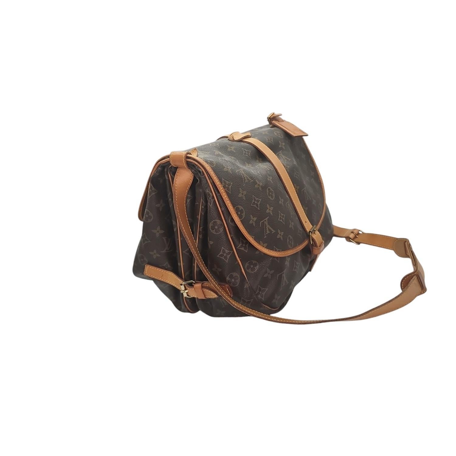 The Louis Vuitton Vintage Monogram Saumur Bag is a timeless piece for any fashion lover. Crafted with brown and tan Monogram coated canvas, this bag also features durable cowhide leather trim, buckle expansions for added space, and buckle closures