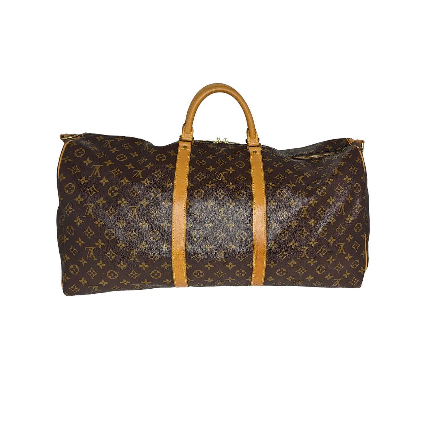 Elevate your travel with the Louis Vuitton Vintage Monogram Keepall Bandouliere 60. Crafted from coated canvas with a zip closure and brass hardware, it offers both style and security. Includes a luggage tag, lock & key, and Entrupy COA. Very good
