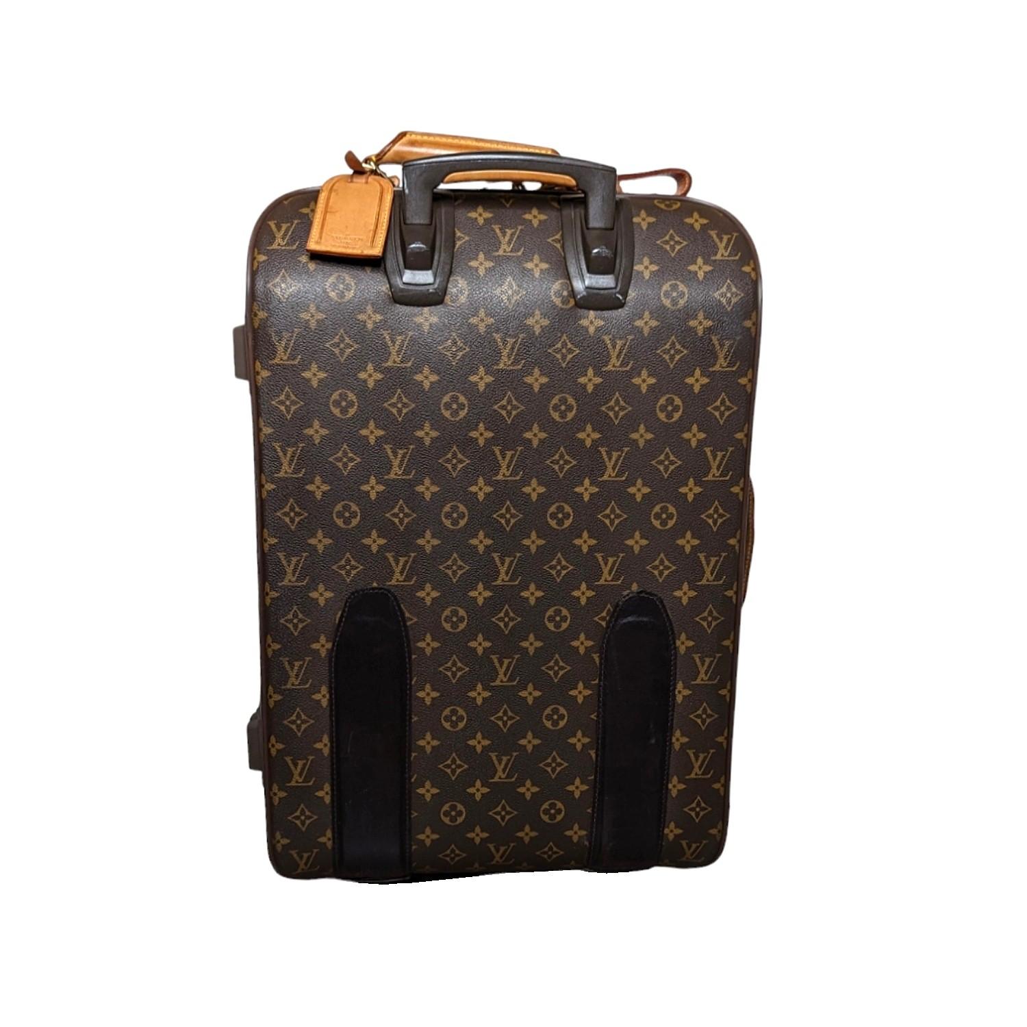 Men's brown and tan monogram coated canvas Louis Vuitton Monogram Pégase 55 with brass hardware, dual handles; one at side and top, retractable pull-handle at top, single exterior pocket at front, dual wheels at base, brown canvas lining, dual