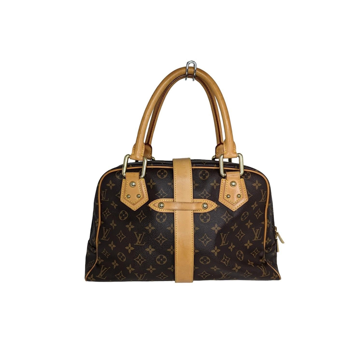 Brown and tan monogram coated canvas Louis Vuitton Manhattan GM with brass hardware, dual rolled top handles, tan vachetta trim, dual flap pockets with push-lock closures at front face, tan Alcantara lining, single interior flat pocket and two-way