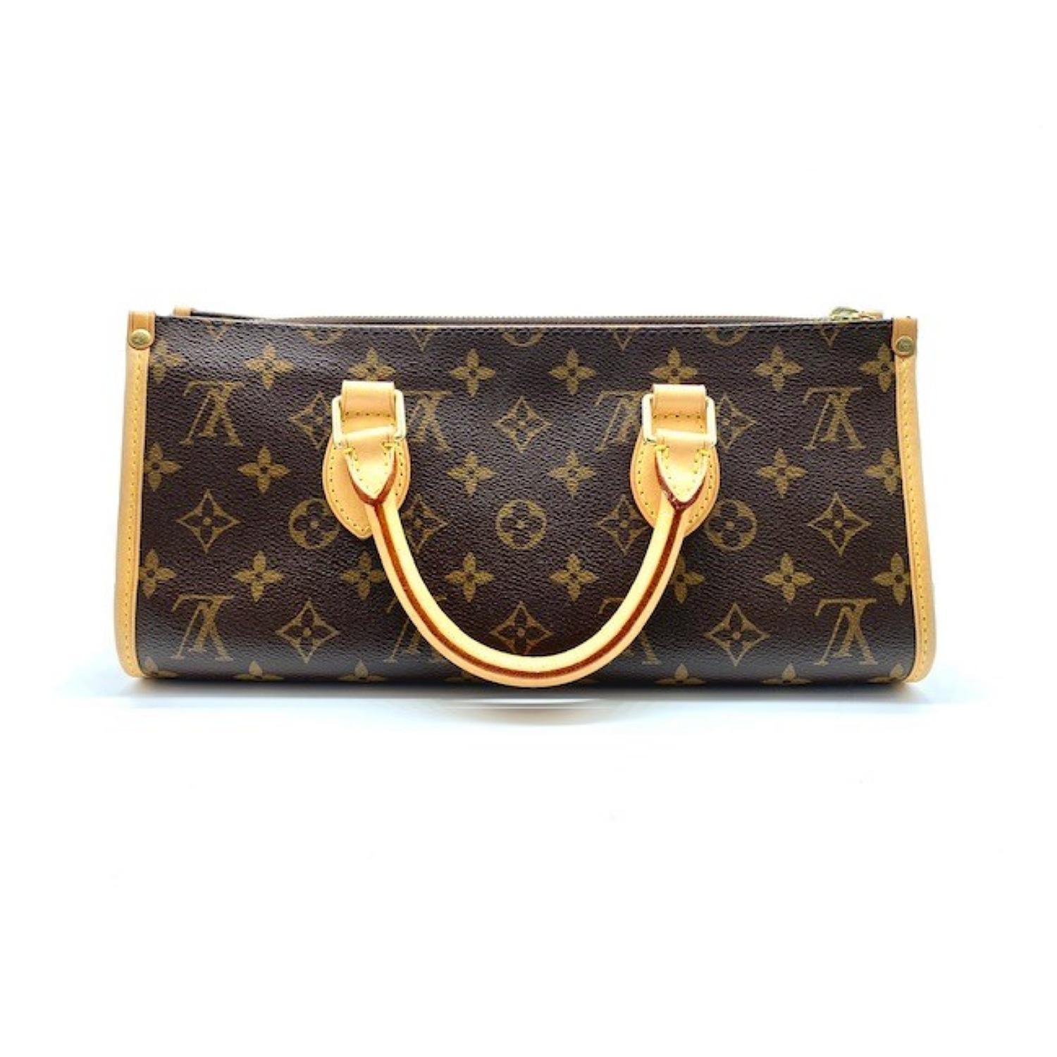 The chic handbag is crafted of traditional Louis Vuitton monogram coated canvas. This is complemented with vachetta cowhide leather trim and rolled leather top handles. The bag has brass hardware including an overhanging zipper that opens to a