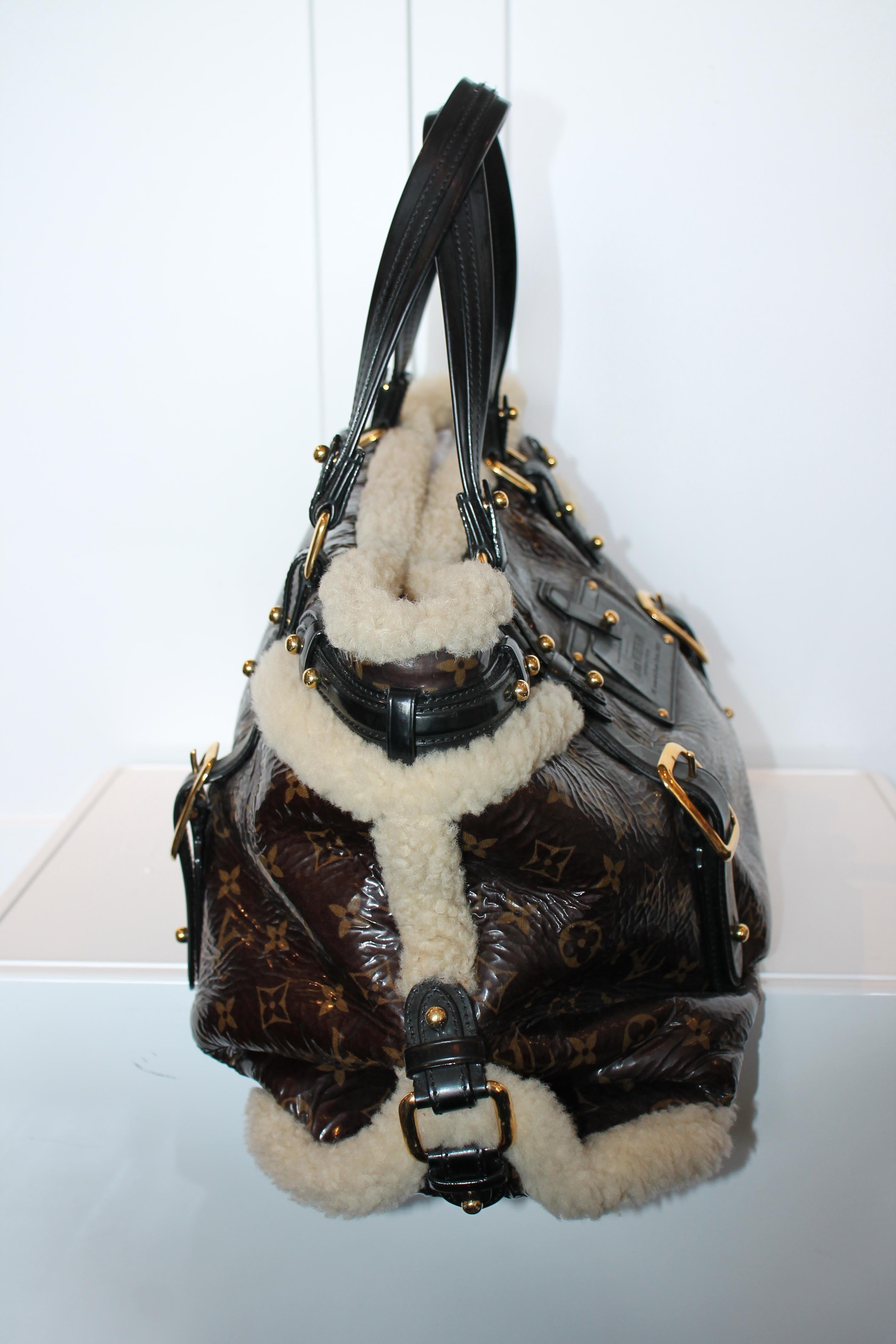 Crafted of Louis Vuitton's Monogram Patent Leather, this rare Shearling Storm Bag is adorned with a Louis Vuitton-embossed Inventeur plaque. Gold-tone hardware features black leather and ivory shearling accents throughout. Double rolled vernis