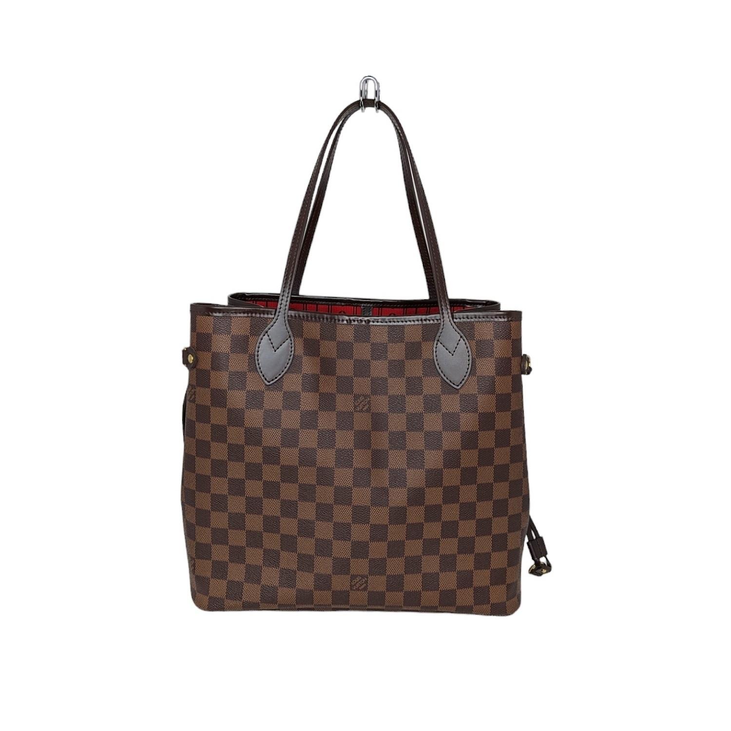 This chic tote is crafted of classic Louis Vuitton Damier in brown on coated canvas. The shoulder bag features chocolate brown cowhide leather trim, shoulder straps, side cinch cords, and has polished brass hardware. The top is open to a striped