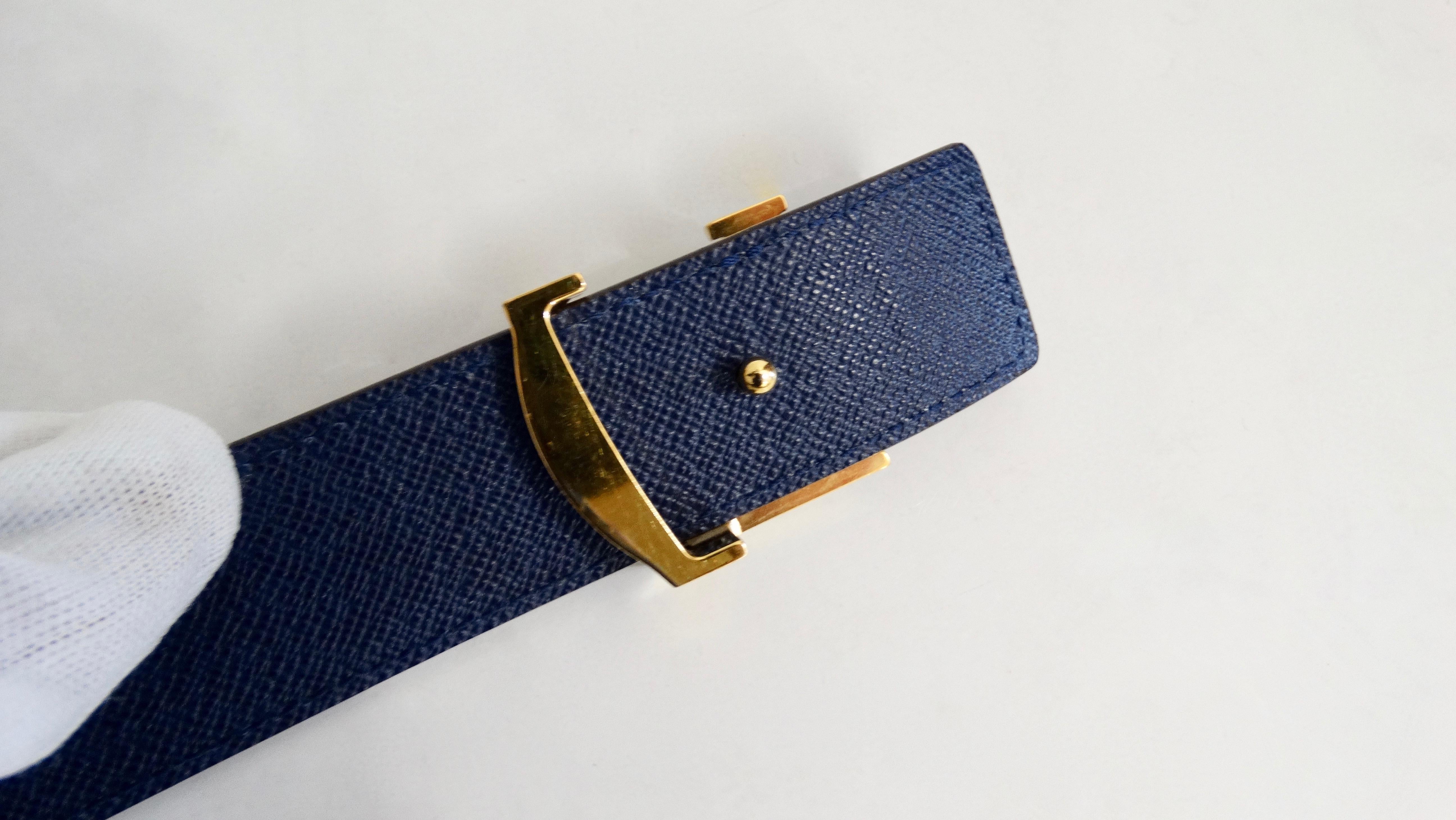 Keep your belt game strong with this Louis Vuitton belt! Circa 2013, this belt is crafted from durable calfskin and features a gold plated LV buckle, the classic LV monogram with blue overlapping and a reversible solid blue leather belt on the