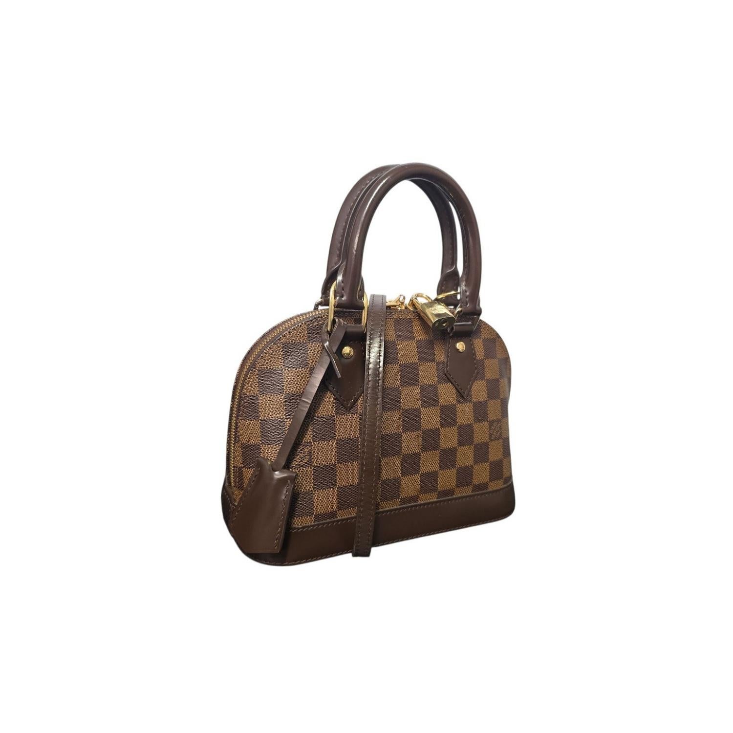 The Louis Vuitton Damier Ebene Alma BB Handbag is a refined reinterpretation of the 1934 Art Deco original, showcasing classic elegance through its structured silhouette and signature details. Crafted from durable Damier Ebene coated canvas with