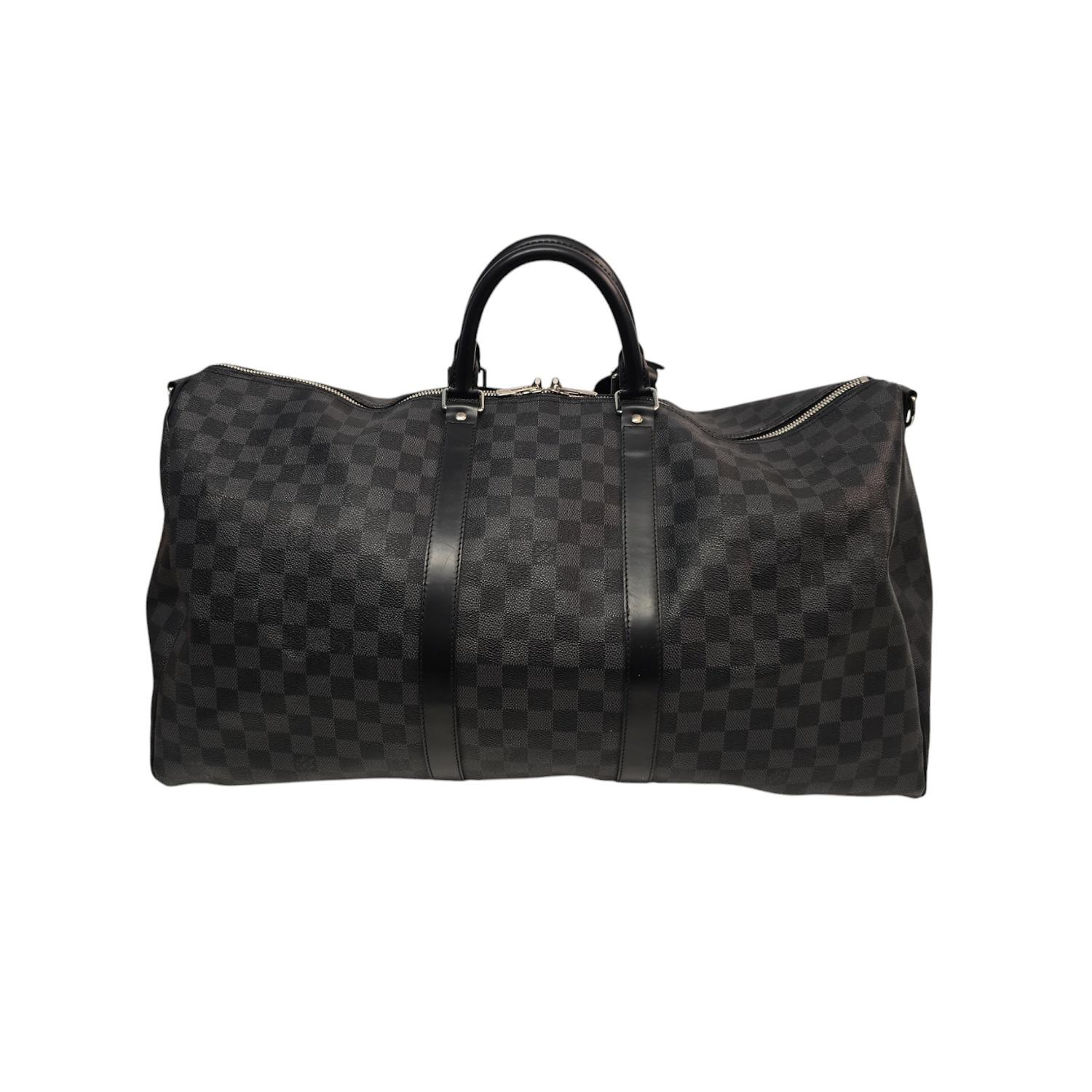 Enhance your travel style with the sophisticated Louis Vuitton Damier Graphite Keepall 55 Bandouliere. Crafted from luxurious Damier check canvas in black and gray, this travel bag features sturdy rolled leather handles and a removable shoulder