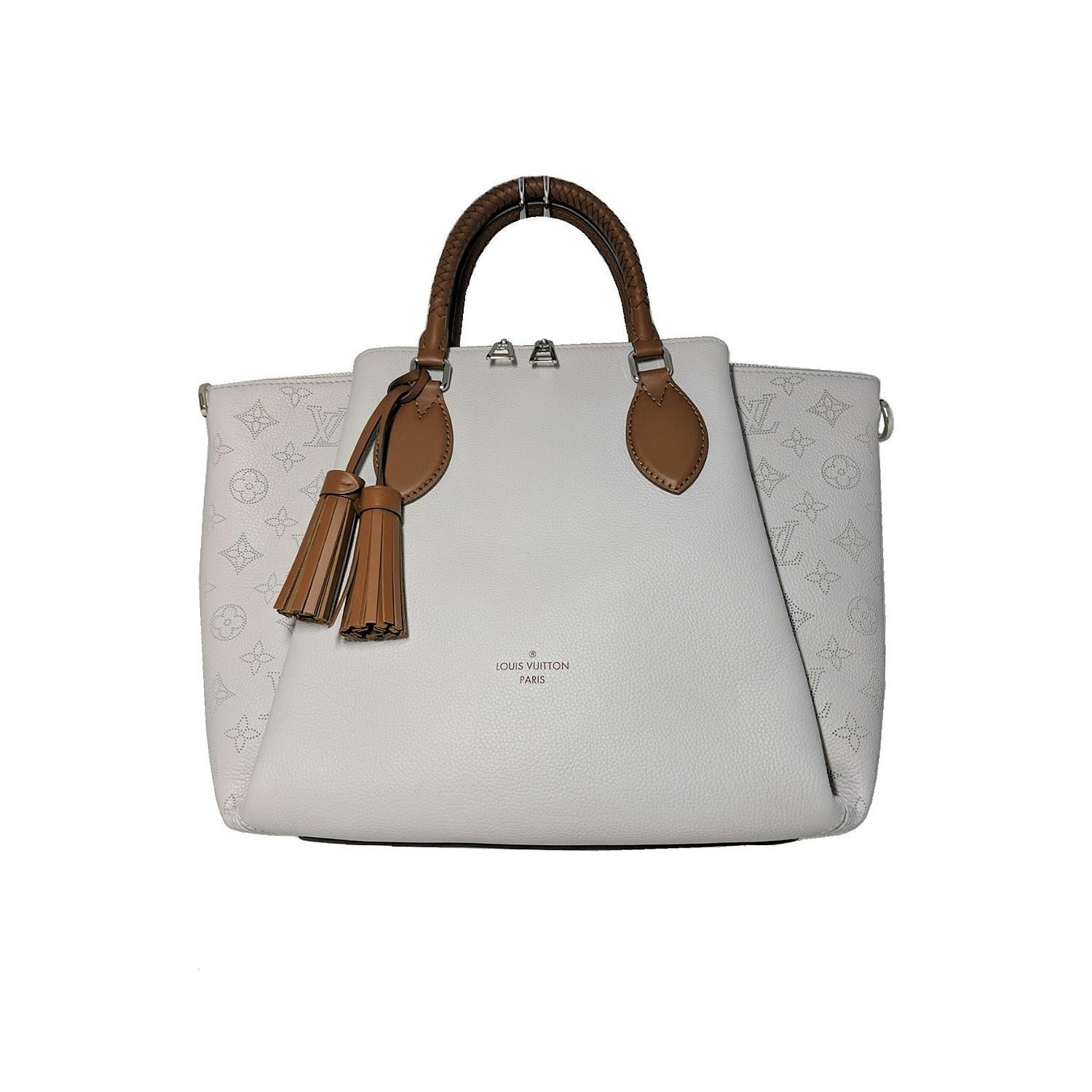 This chic handbag is crafted of grained calfskin leather. The shoulder bag features braided rolled beige leather top handles with matching tassel detailing at the front and silver hardware. This opens to a brown suede interior with flat pockets.
