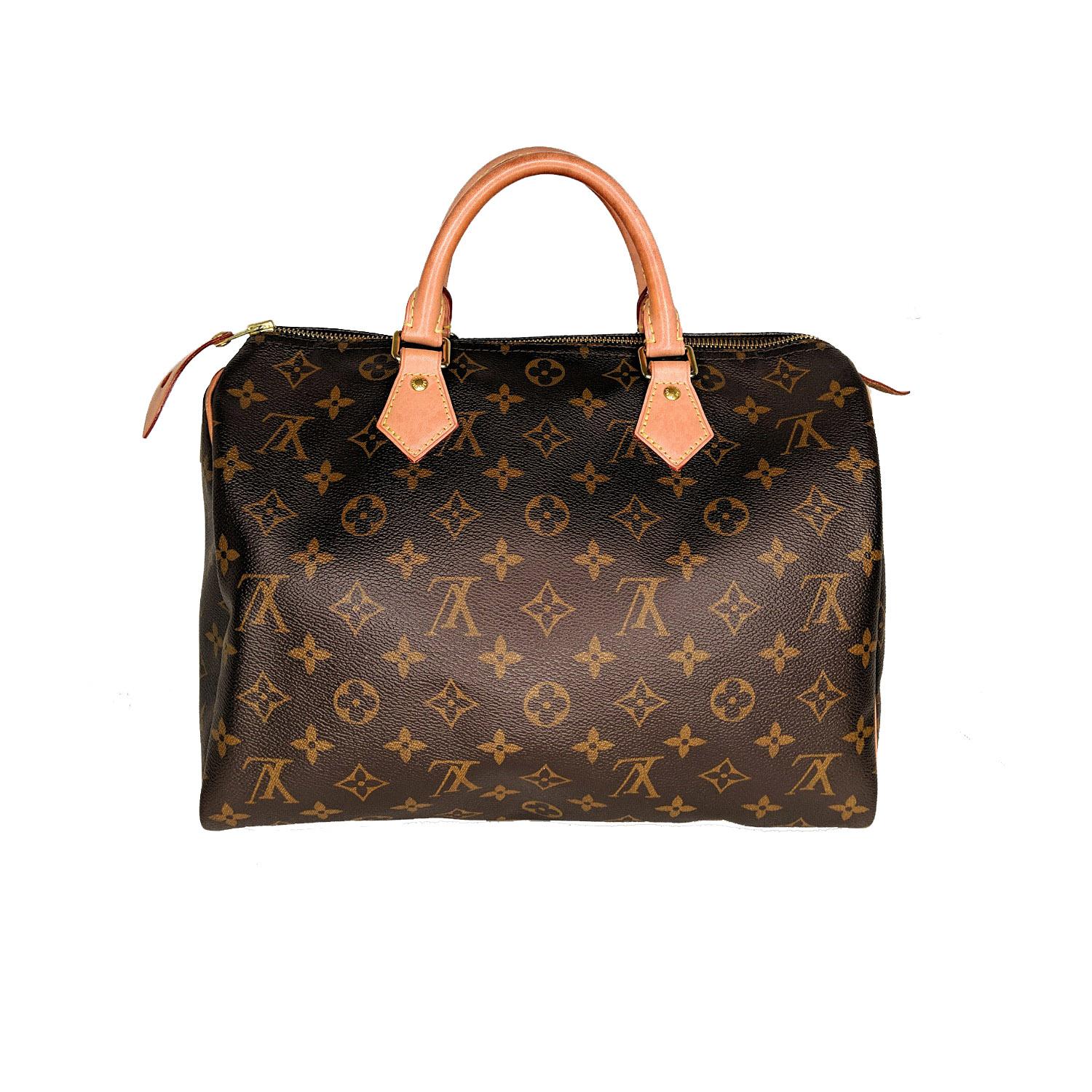 Brown and tan Monogram coated canvas Louis Vuitton Speedy 30 with brass hardware, tan Vachetta leather trim, dual rolled top handles, brown canvas lining, single patch pocket at interior wall and zip closure at top. 

Designer: Louis