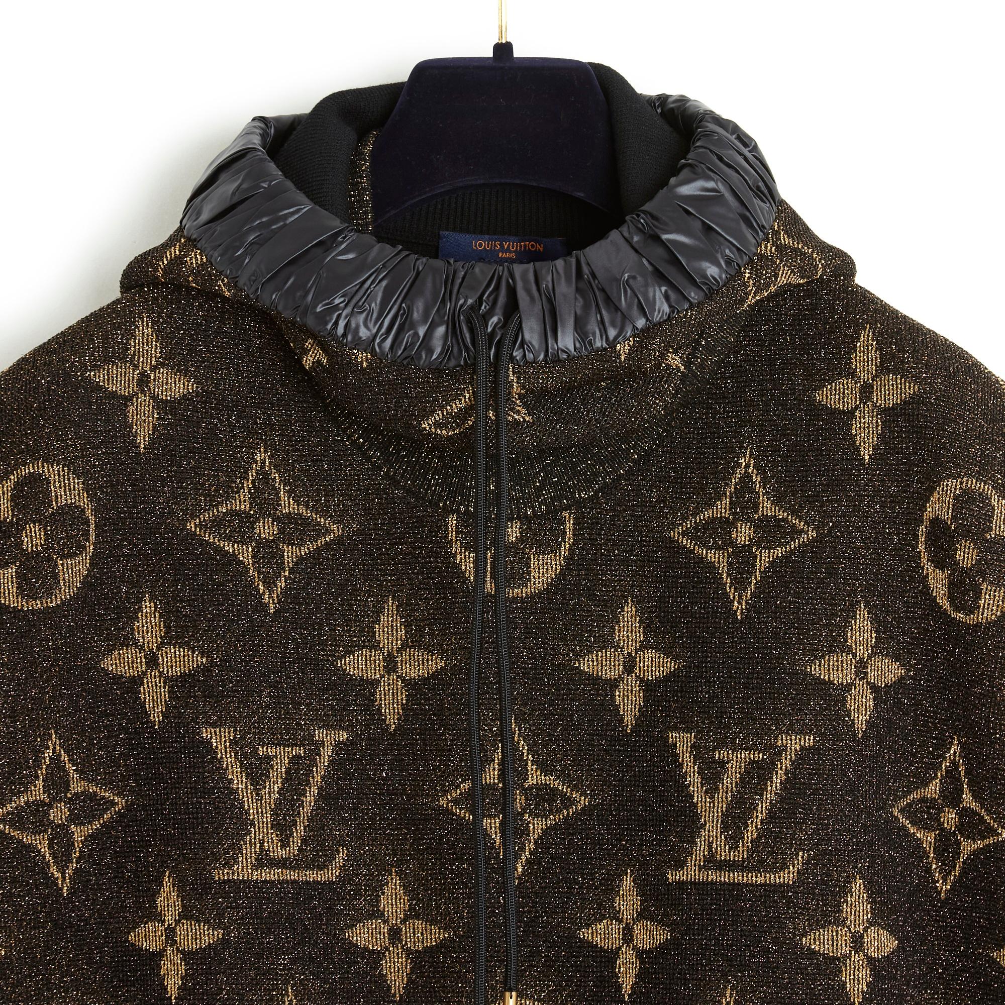 Louis Vuitton top, oversized volume sweatshirt style, in wool blend jacquard knit, monogram pattern in black, bronze and gold tones, sleeveless, round neck with removable hood lined with black technical fabric with tightening tie, held in place by 3
