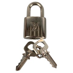 LOUIS VUITTON, padlock in yellow metal with key. Vintage Clothing &  Accessories - Auctionet