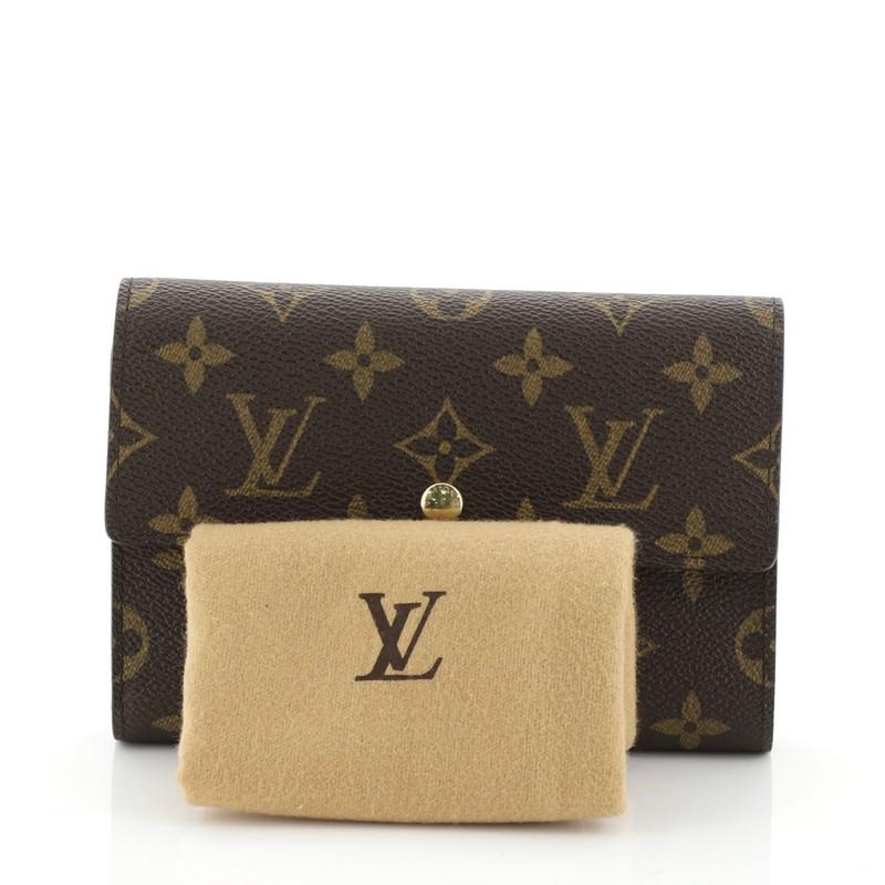 This Louis Vuitton Alexandra Wallet Monogram Canvas, crafted from brown monogram coated canvas, features gold-tone hardware. Its snap button closure opens to a brown leather interior with multiple card slots and zip and slip pockets. Authenticity