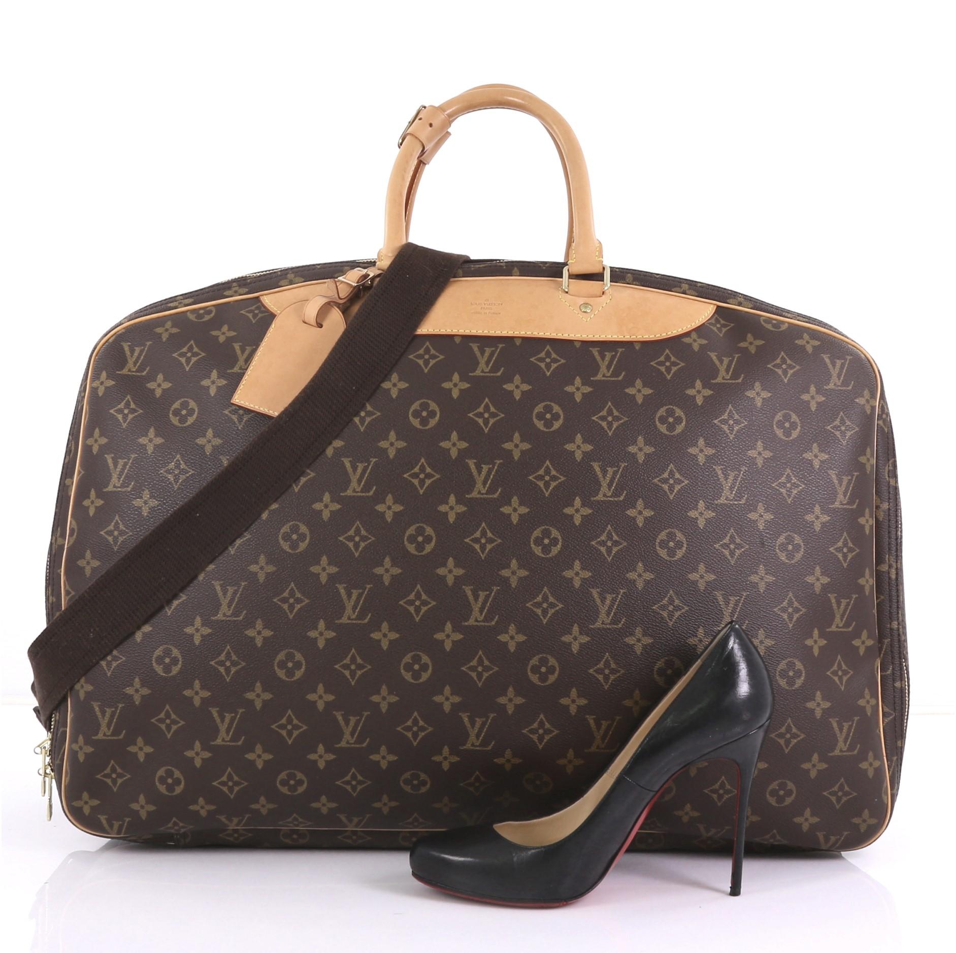 This Louis Vuitton Alize Bag Monogram Canvas 3 Poches, crafted in brown monogram coated canvas, features dual rolled leather handles and gold-tone hardware. Its double zip-around closure opens into three separate beige canvas interior compartments