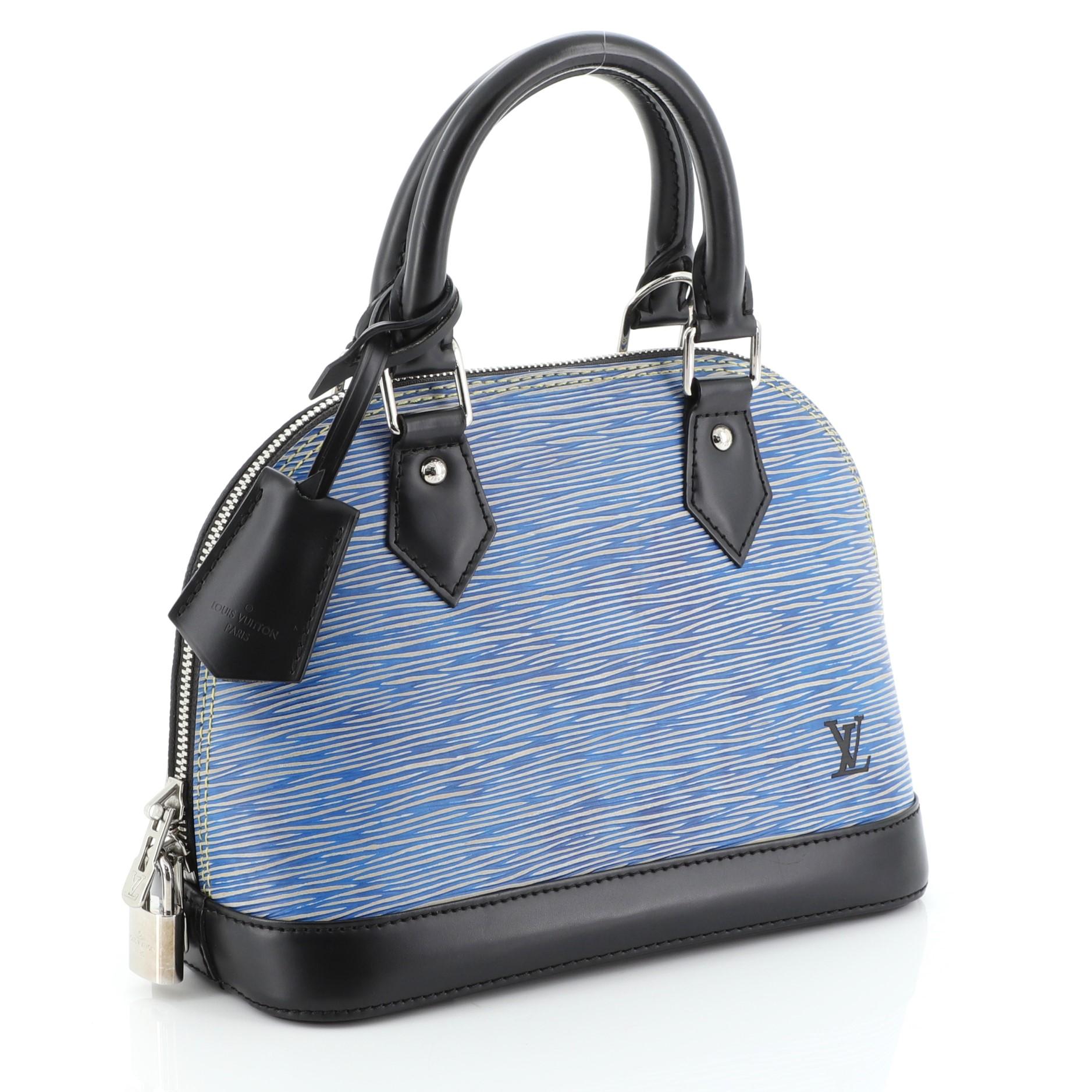 This Louis Vuitton Alma Handbag Epi Leather BB is a classic piece named after Alma Bridge, a span that connects two Parisian neighborhoods. Crafted in blue epi leather, features dual rolled leather handles and silver-tone hardware. Its all-around