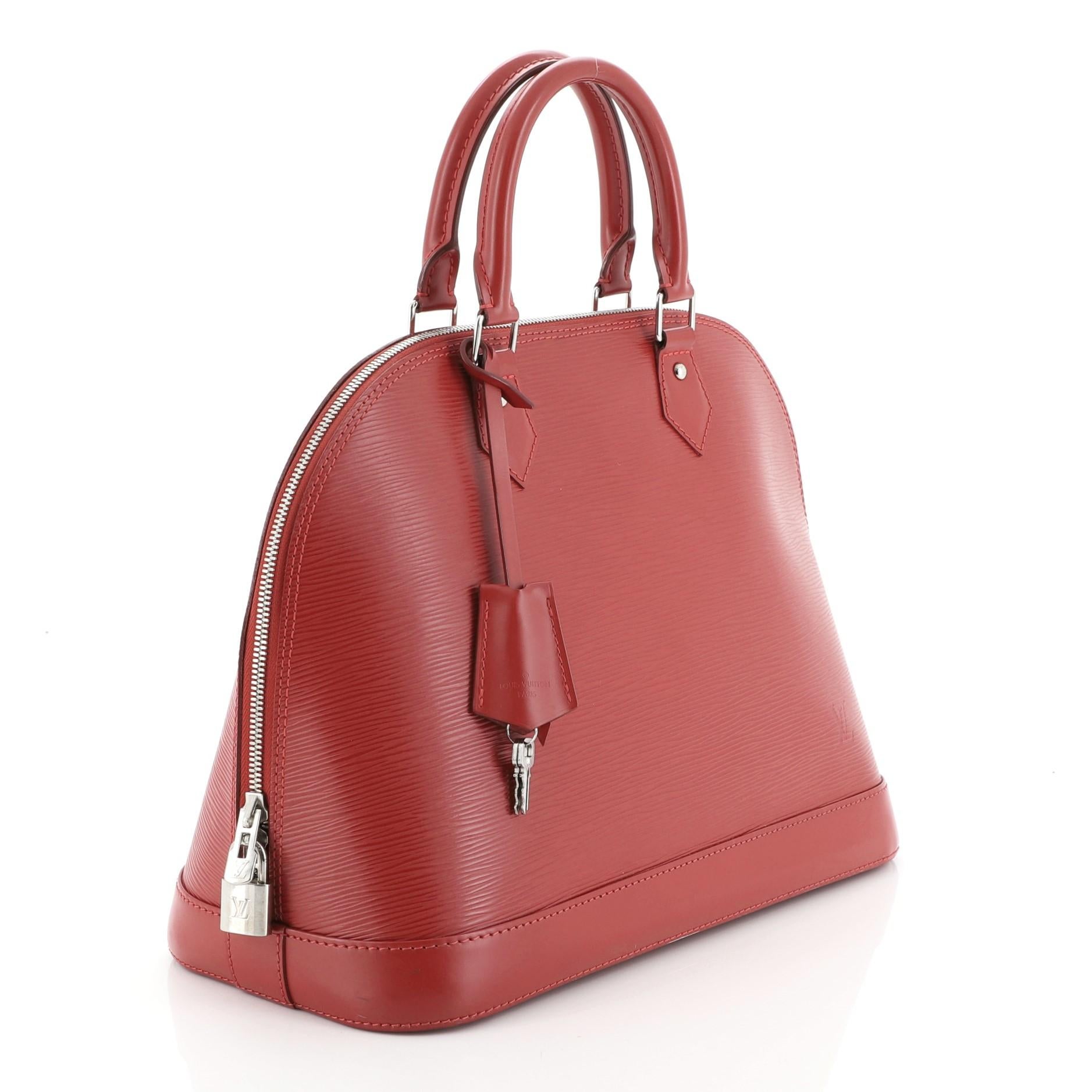 This Louis Vuitton Alma Handbag Epi Leather MM, crafted in red epi leather, features dual-rolled handles, protective base studs, and silver-tone hardware. Its all-around zip closure opens to a red microfiber interior with slip pockets. Authenticity