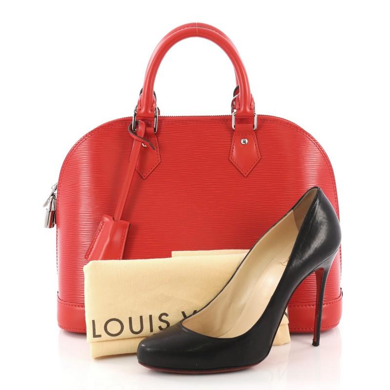 This Louis Vuitton Alma Handbag Epi Leather PM, crafted from red epi leather, features dual rolled handles and silver-tone hardware. Its all-around zip closure opens to a red microfiber interior with slip pocket. Authenticity code reads: SD5104.