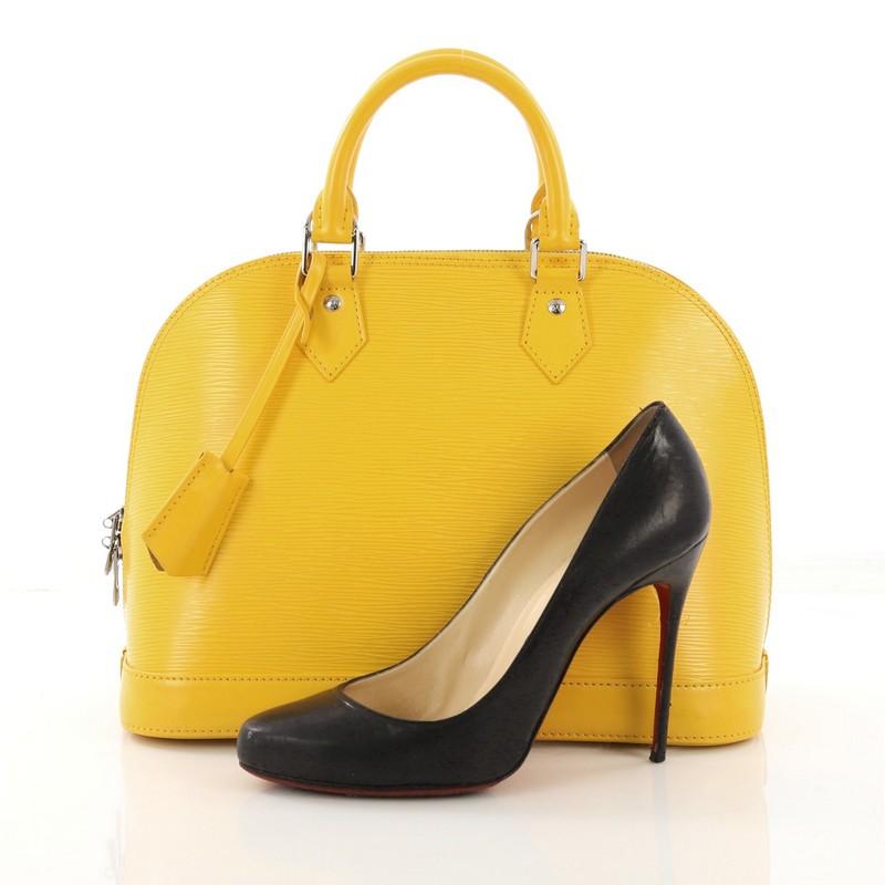 This Louis Vuitton Alma Handbag Epi Leather PM, crafted from yellow epi leather, features dual rolled handles and silver-tone hardware. Its all-around zip closure opens to a yellow microfiber interior with slip pocket. Authenticity code reads: