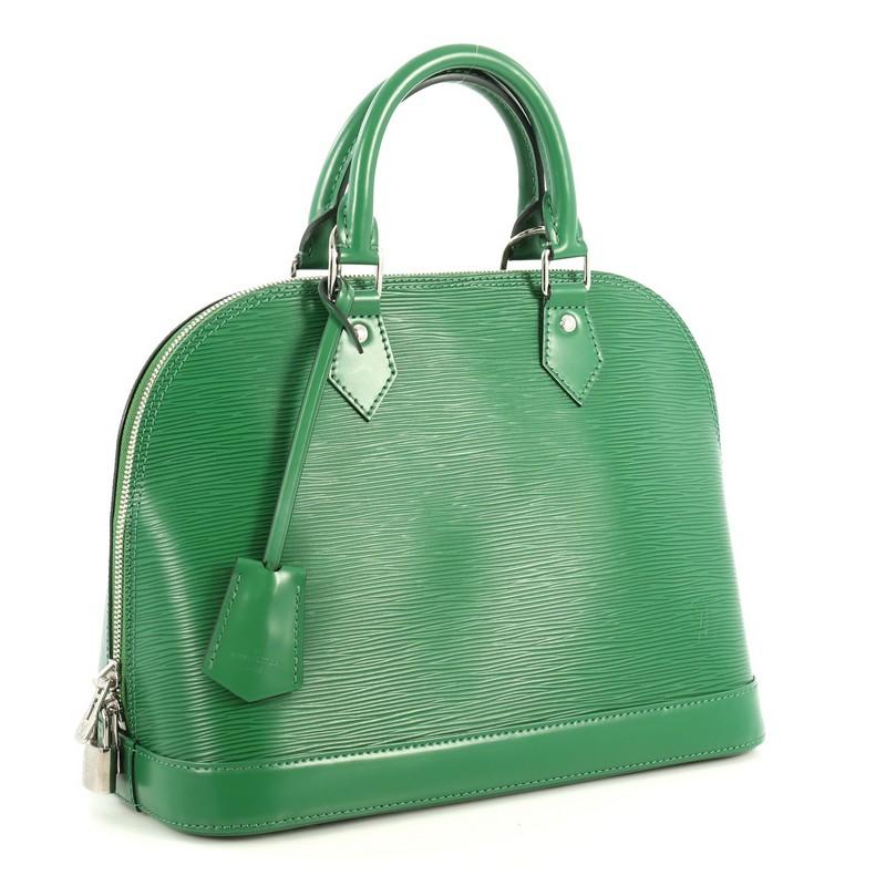 This Louis Vuitton Alma Handbag Epi Leather PM, crafted in green epi leather, features dual rolled leather handles, protective base studs, and silver-tone hardware. Its all-around zip closure opens to a green microfiber interior with slip pockets.