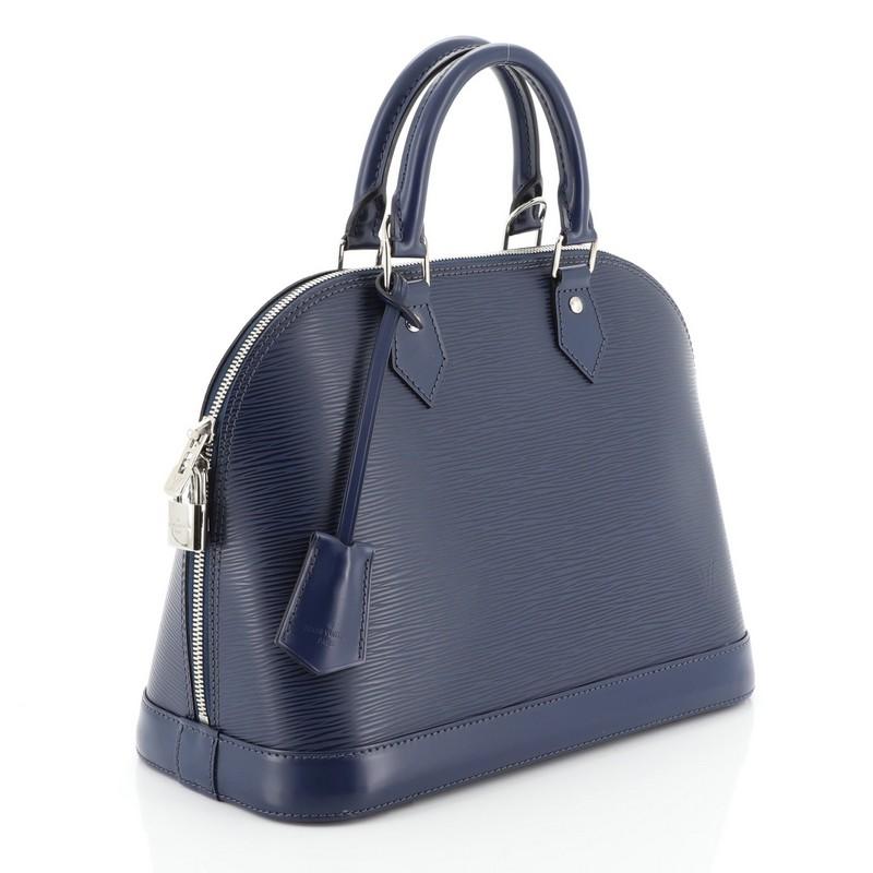 This Louis Vuitton Alma Handbag Epi Leather PM, crafted in blue epi leather, features dual rolled leather handles, protective base studs, and silver-tone hardware. Its all-around zip closure opens to a blue microfiber interior with slip pockets.