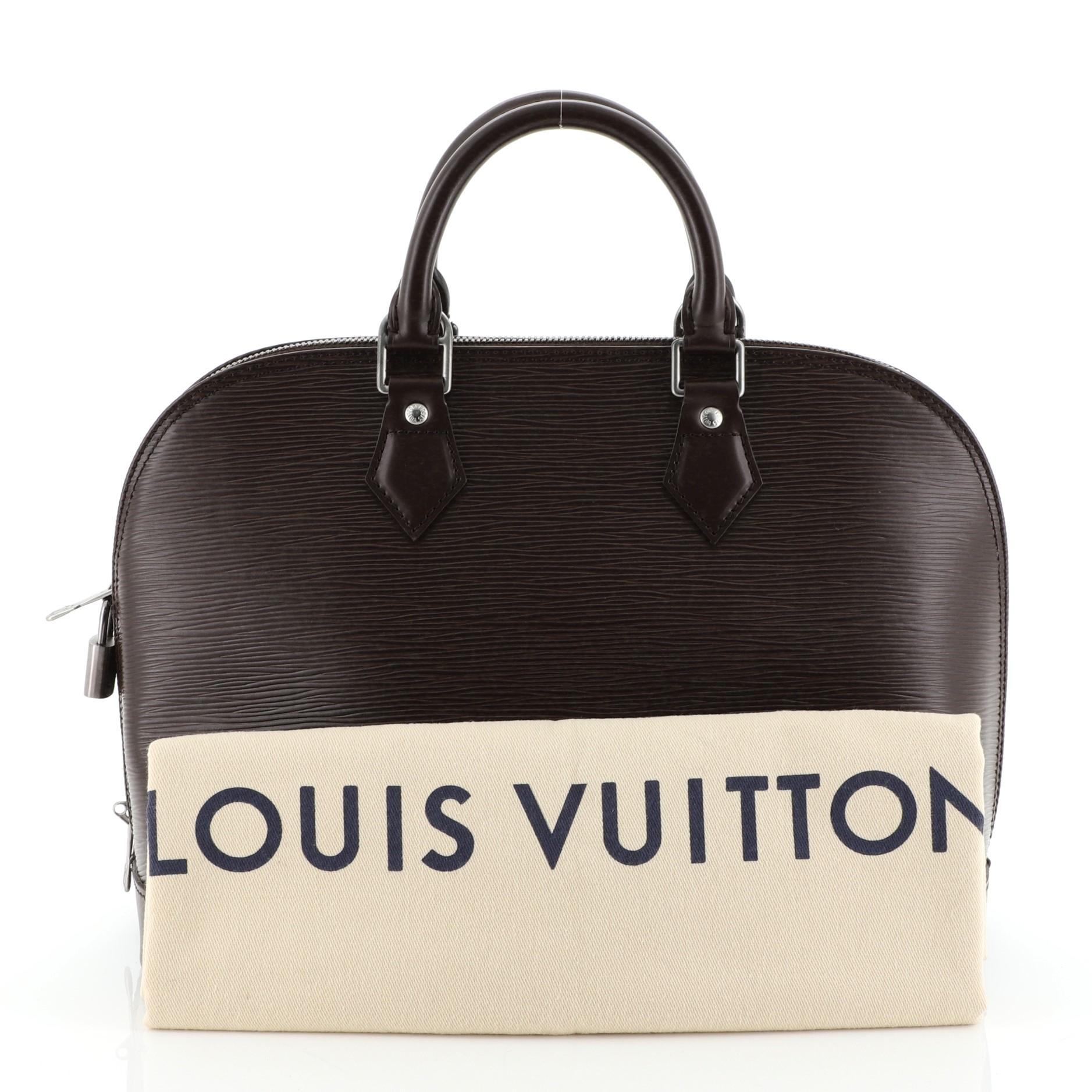 This Louis Vuitton Alma Handbag Epi Leather PM, crafted in brown epi leather, features dual rolled leather handles, protective base studs, and matte silver-tone hardware. Its all-around zip closure opens to a brown microfiber interior with slip