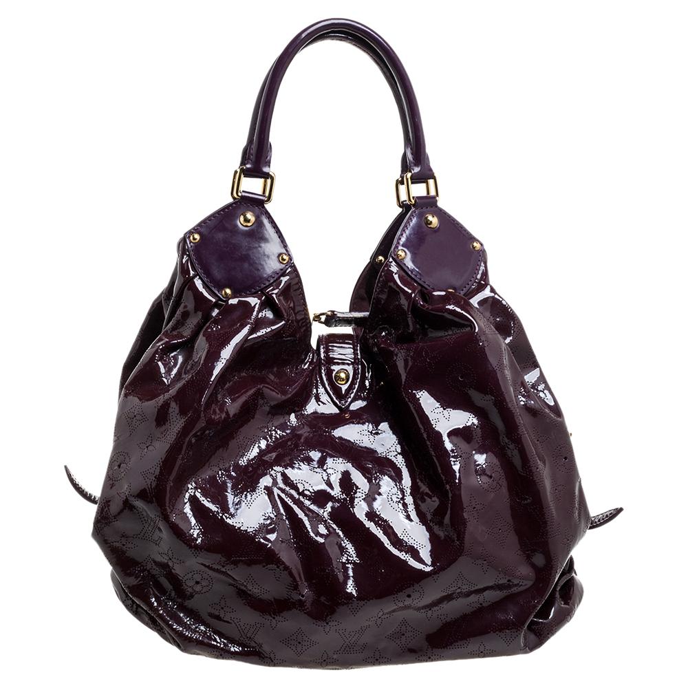 This Louis Vuitton limited edition Surya bag is designed exquisitely. Its glossy, burgundy body is inspired by the Hindu Sun God, Surya. Feminine and chic, this slouchy bag is roomy and perfect for everyday use. Crafted from intricate perforated LV