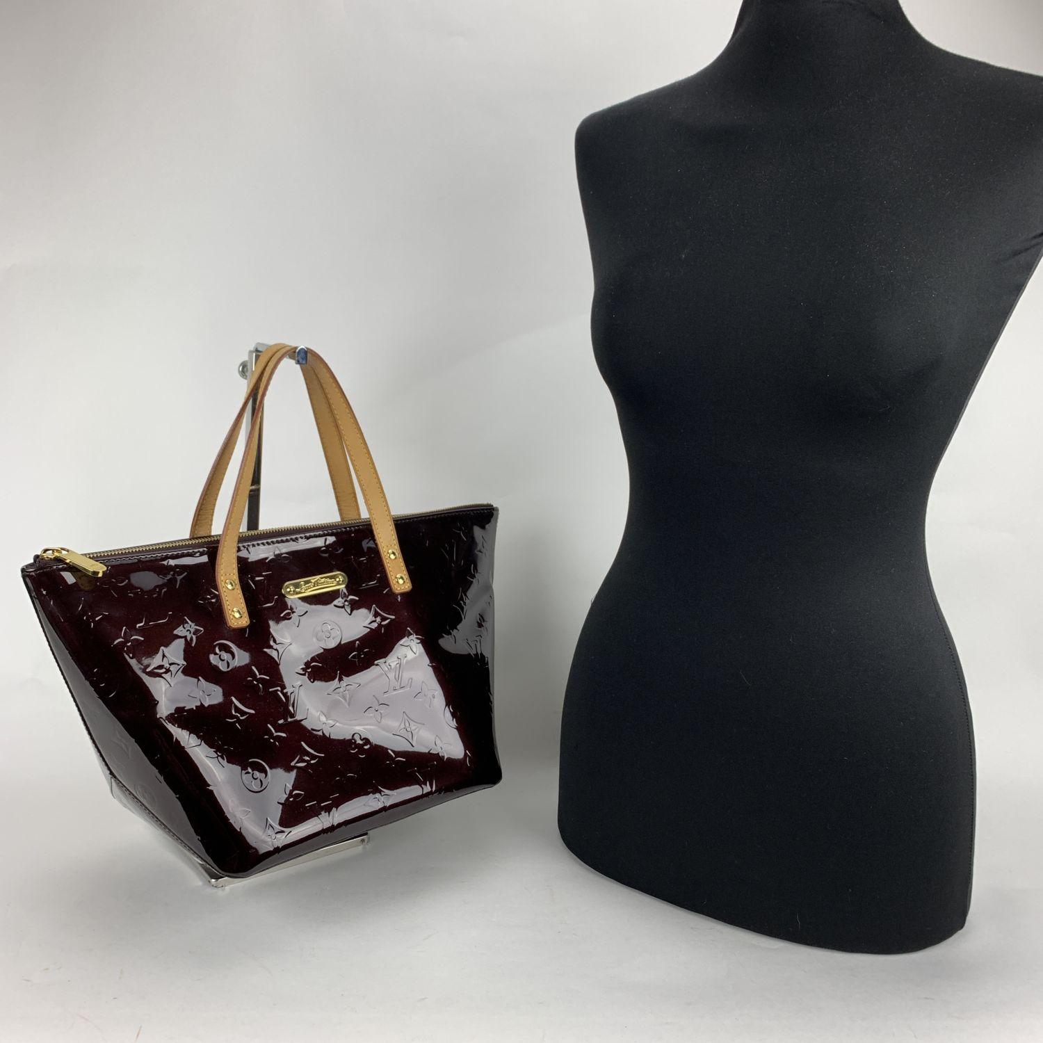 Sophisticated 'Bellevue PM' Tote Bag by LOUIS VUITTON, crafted in amarante Monogram Vernis leather. The bag features a large main compartment with upper zipper closure. Purple fabric internal lining with 1 side open pocket inside. 'LOUIS VUITTON
