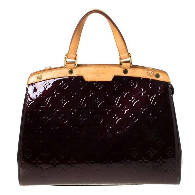 The feminine shape of Louis Vuitton's Brea is inspired by the doctor's bag. Crafted from Monogram Vernis patent leather, the bag has a perfect finish. The fabric interior is spacious and it is secured by a zipper. The bag features double handles, a