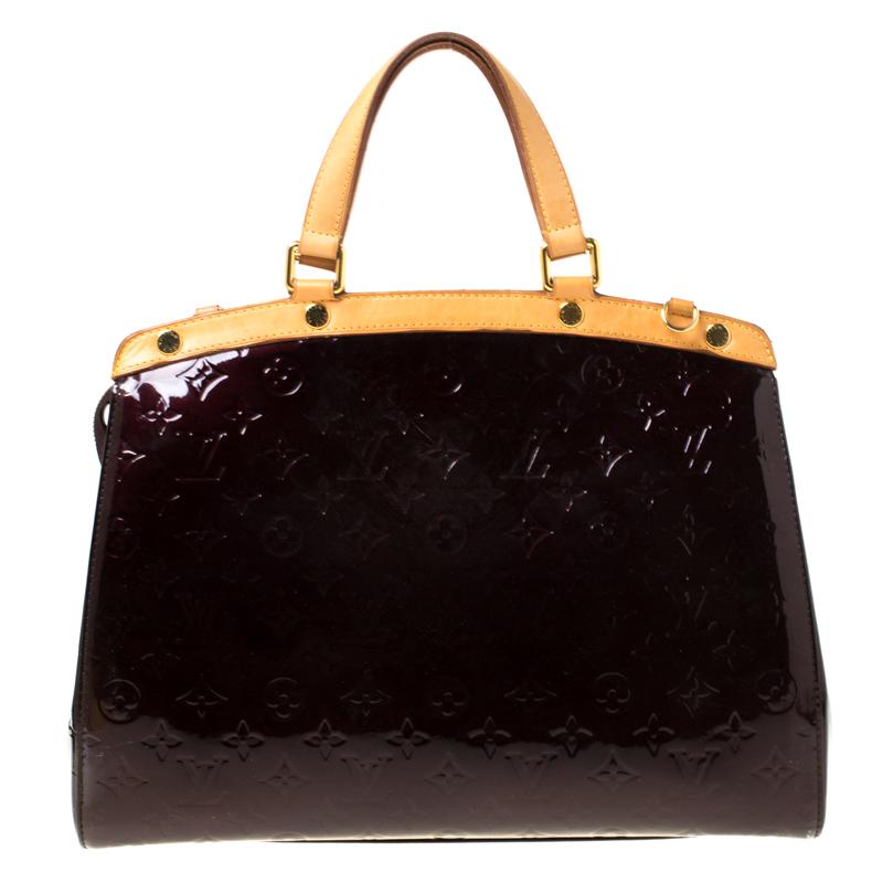 The feminine shape of Louis Vuitton's Brea is inspired by the doctor's bag. Crafted from Monogram Vernis patent leather, the bag has a perfect finish. The fabric interior is spacious and it is secured by a zipper. The bag features double handles, a