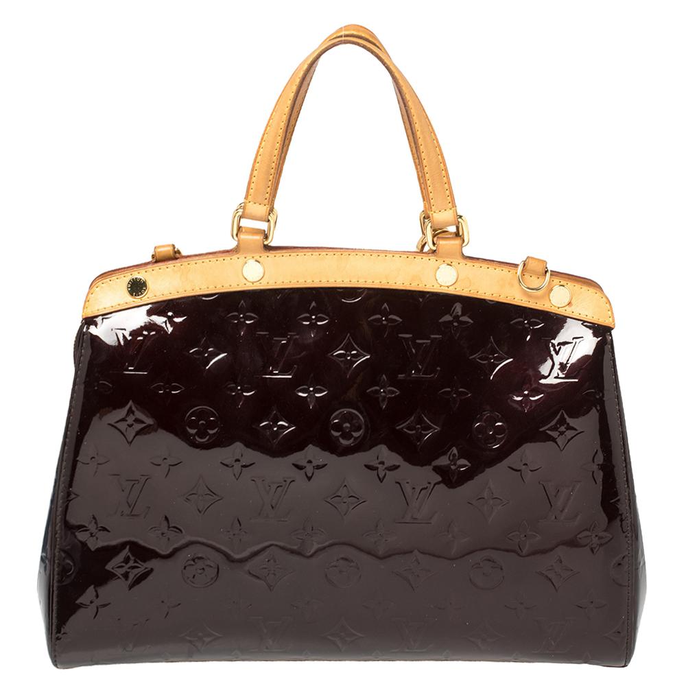 The feminine shape of Louis Vuitton's Brea is inspired by the doctor's bag. Crafted from monogram vernis in burgundy, the bag has a perfect finish. The fabric interior is spacious and it is secured by a zipper. The bag features double handles, a