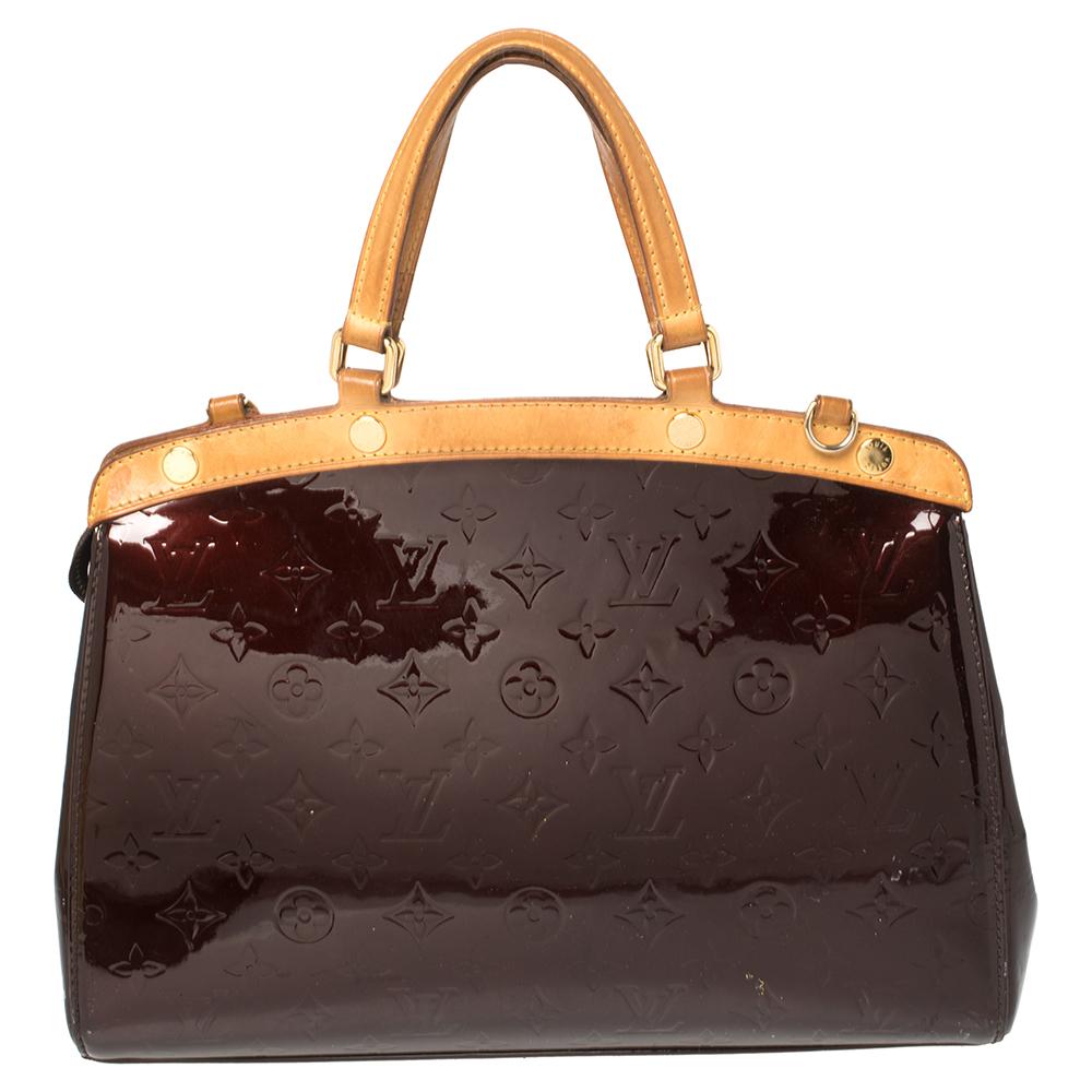 The feminine shape of Louis Vuitton's Brea is inspired by the doctor's bag. Crafted from Monogram Vernis in Amarante shade, the bag has a perfect finish. The fabric interior is spacious and it is secured by a zipper. The bag features double handles,